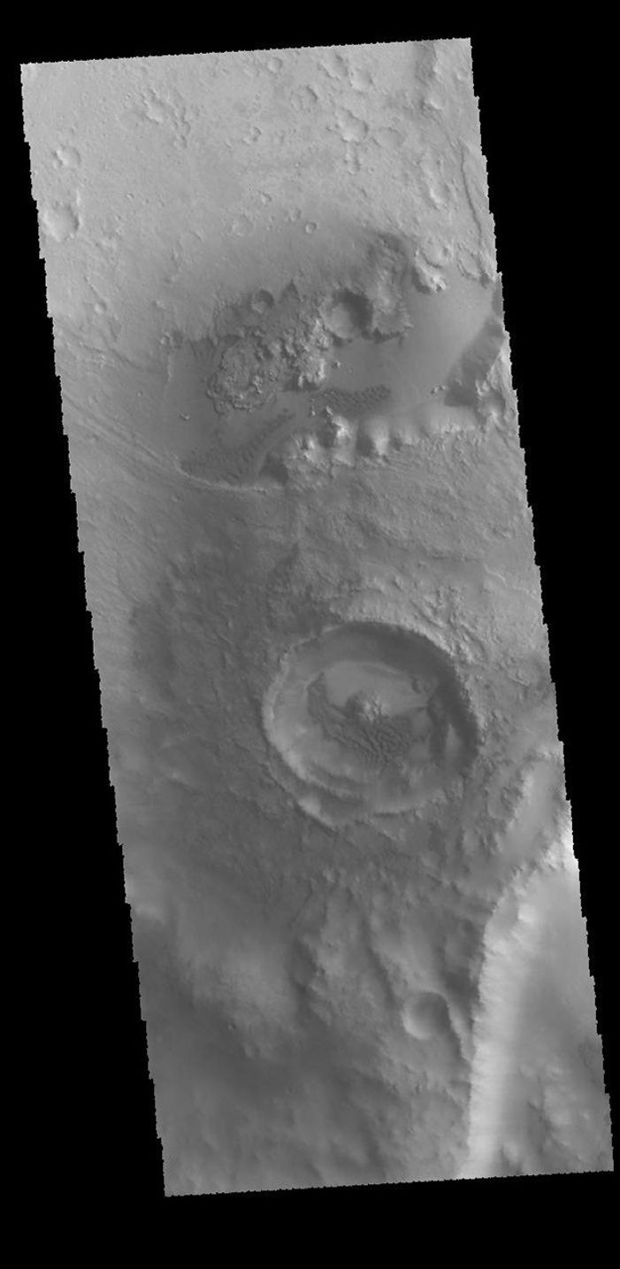 This image captured by NASA's 2001 Mars Odyssey spacecraft shows a small crater located on the floor of a larger crater. Sand dunes are visible on the floors of both craters.