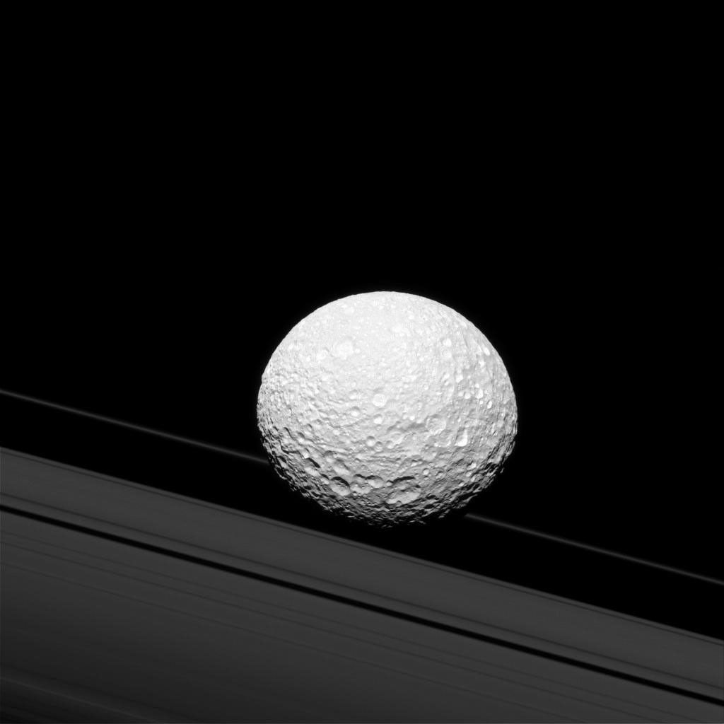 It may look as though Saturn's moon Mimas is crashing through the rings in this image taken by NASA's Cassini spacecraft, but Mimas is actually 28,000 mi (45,000 km) away from the rings. There is a strong connection between the icy moon and Saturn's rings