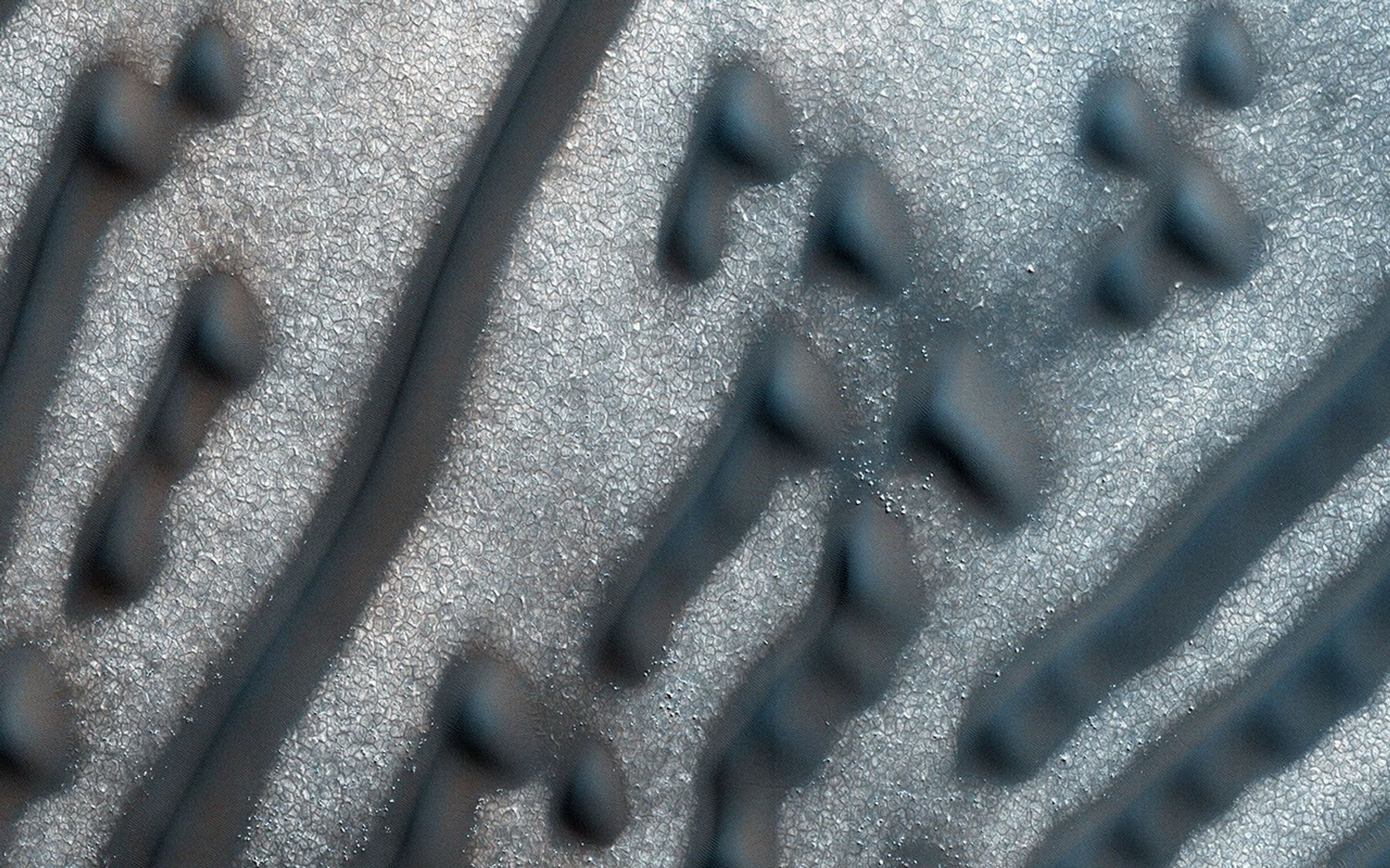 The dunes shown here, as seen by NASA's Mars Reconnaissance Orbiter spacecraft, form distinct dots and dashes. The 'dashes' are linear dunes formed by bi-directional winds, which are not traveling parallel to the dune.