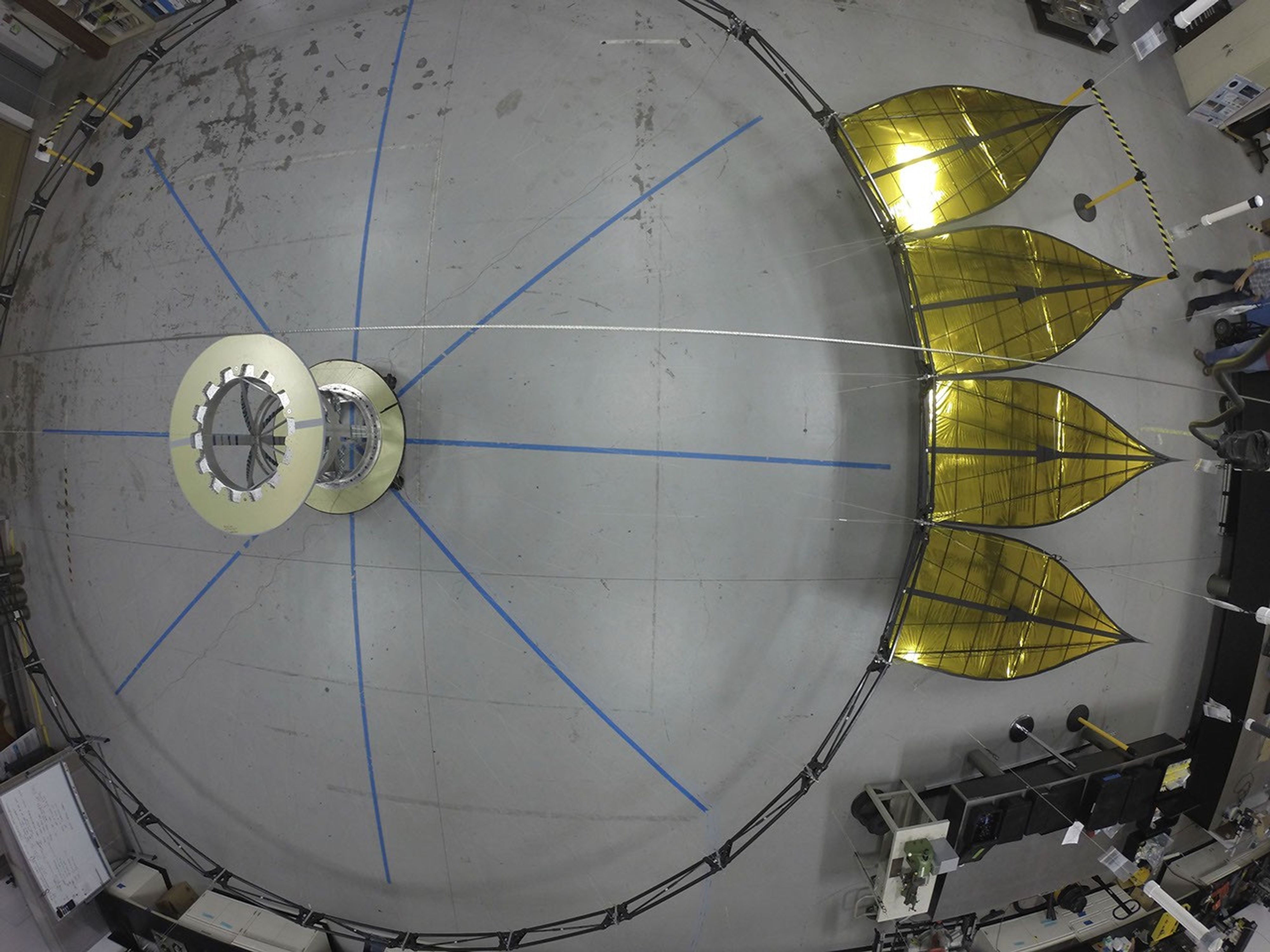 A deployed half-scale starshade with four petals at NASA's Jet Propulsion Laboratory, Pasadena, CA., in 2014. The flower-like petals of the starshade are designed to diffract bright starlight away from telescopes seeking the dim light of exoplanets.