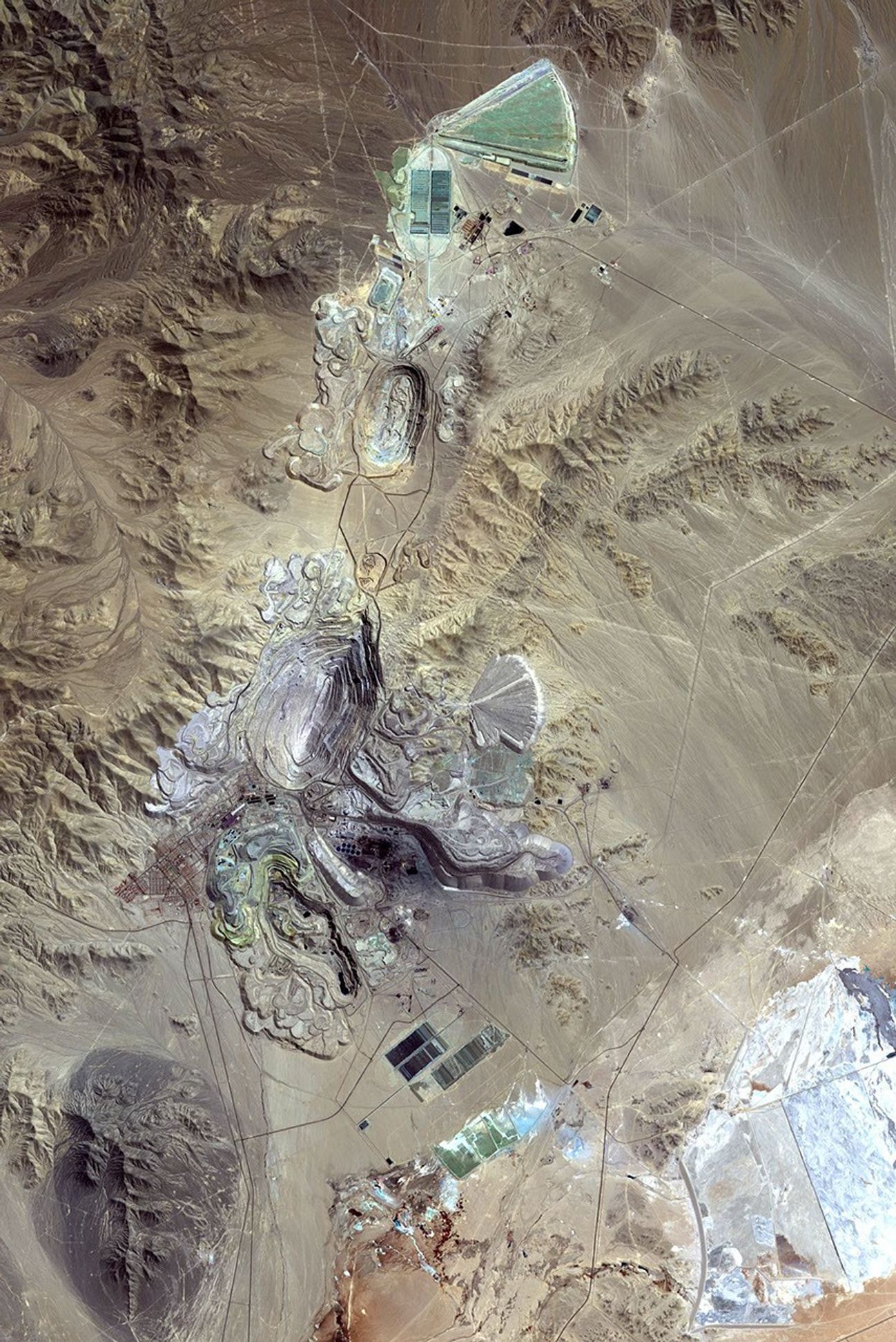 This image from NASA's Terra spacecraft shows Chuquicamata, in Chile's Atacama Desert, which is the largest open pit copper mine in the world, by excavated volume.