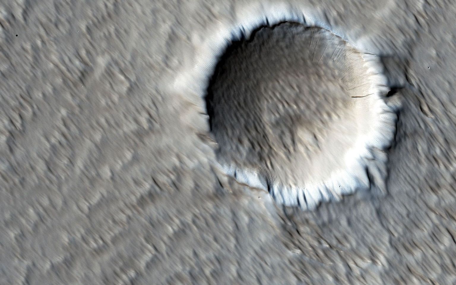 This image from NASA's Mars Reconnaissance Orbiter shows a circular impact crater and an oval volcanic caldera on the southern flank of a large volcano on Mars called Pavonis Mons.
