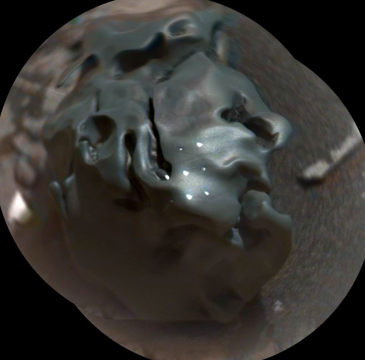 The dark, golf-ball-size object in this composite, colorized view from NASA's Curiosity Mars rover shows a grid of shiny dots where ChemCam had fired laser pulses used for determining the chemical elements in the target's composition.