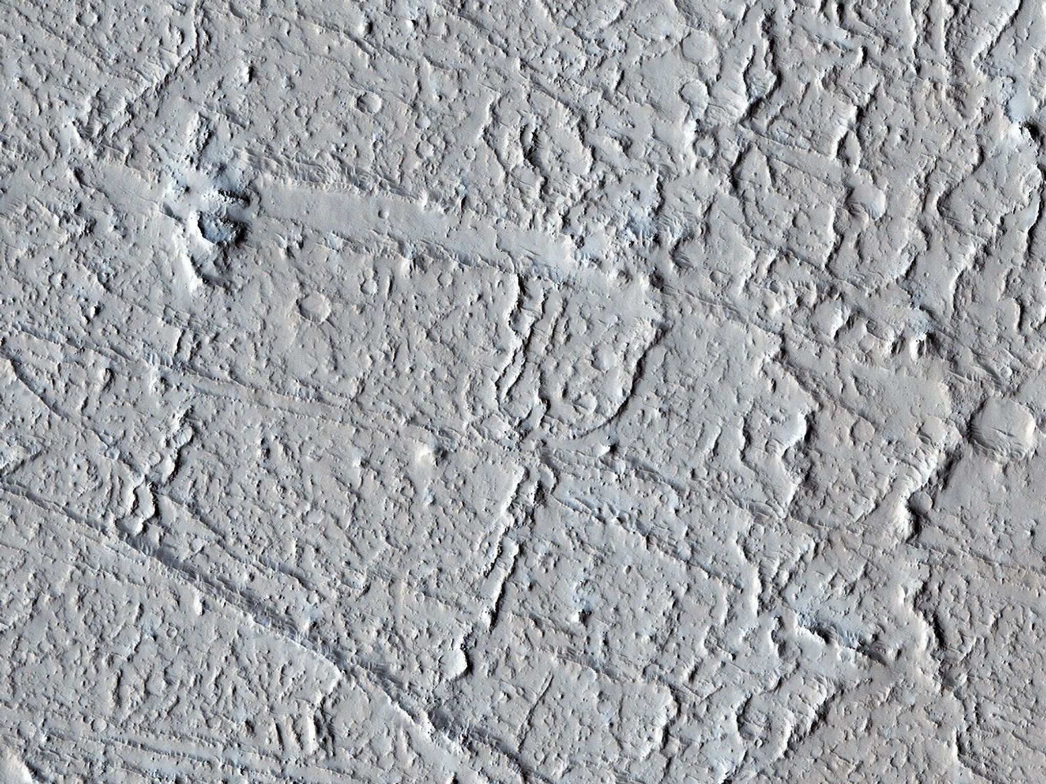This area of Amazonis Planitia to the west of the large volcano Olympus Mons was once flooded with lava as seen by NASA's Mars Reconnaissance Orbiter. A huge eruption flowed out across the relatively flat landscape.