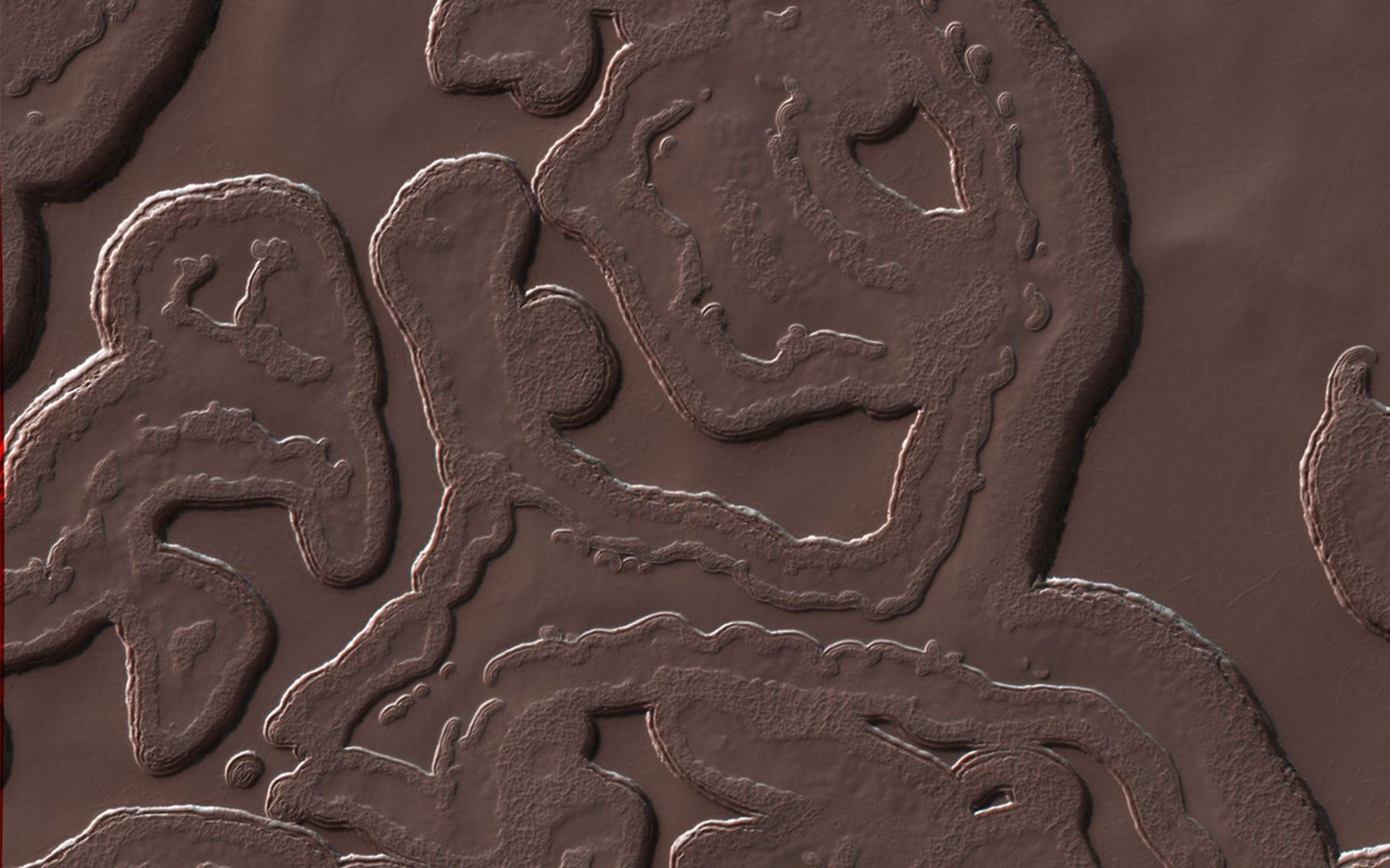 This image from NASA's Mars Reconnaissance Orbiter shows one of these exotic locales at the South Pole. The polar cap is made from carbon dioxide (dry ice). The circular pits are holes in this dry ice layer that expand by a few meters each Martian year.