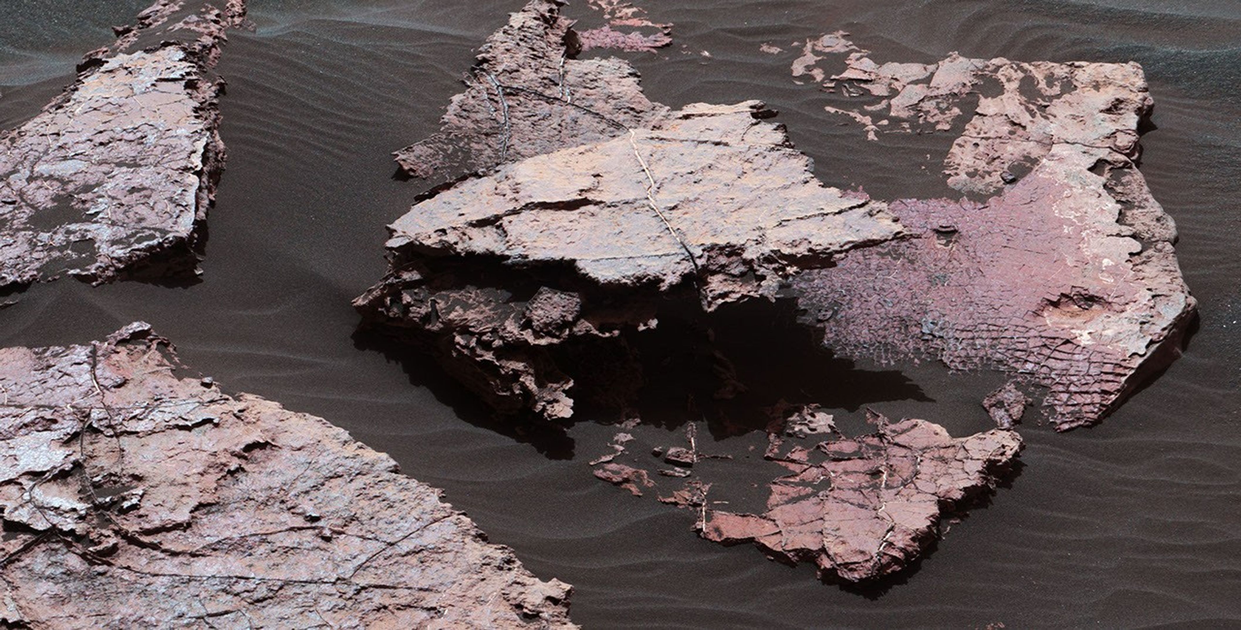 A grid of small polygons on the Martian rock surface near the right edge of this view may have originated as cracks in drying mud more than 3 billion years ago. Multiple images of this view were combined for this view from NASA's Curiosity Mars rover.