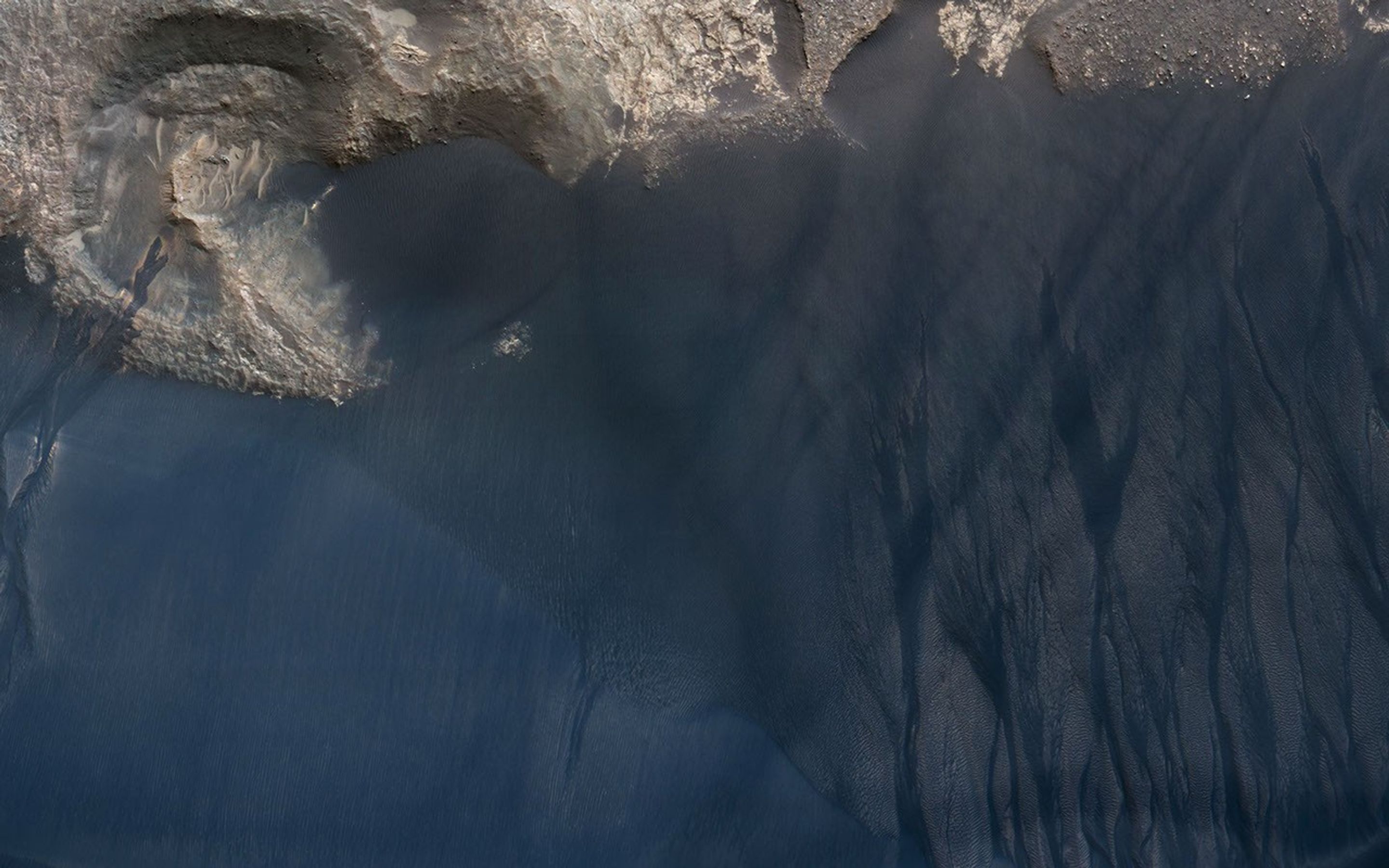 NASA's Mars Reconnaissance Orbiter spied this large crescent dune in Kaiser Crater showing the scars of many types of seasonal erosional activities.