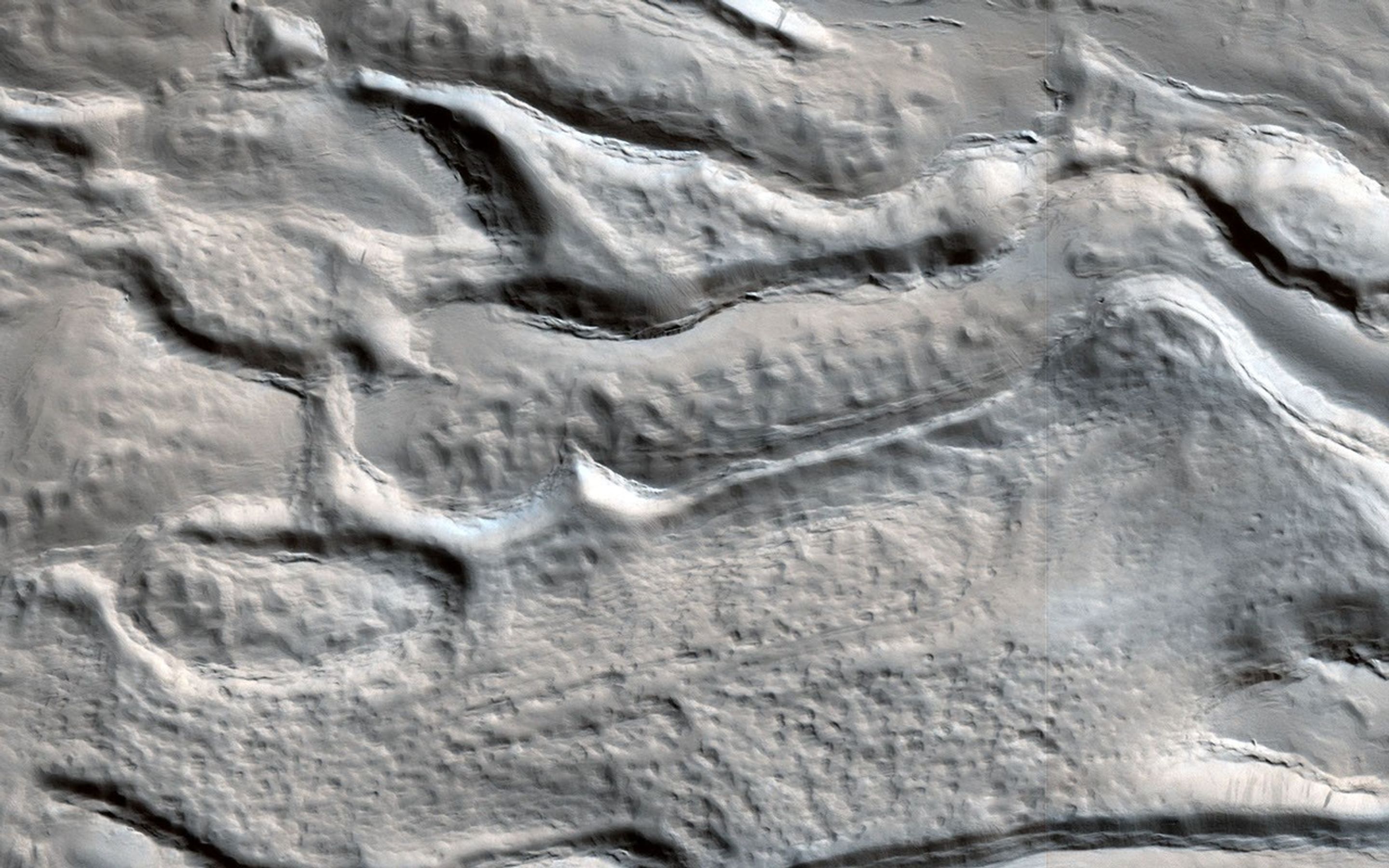 The material on the floor of this crater appears to have flowed like ice, and contains pits that might result from sublimation of subsurface ice, as seen by NASA's Mars Reconnaissance Orbiter.