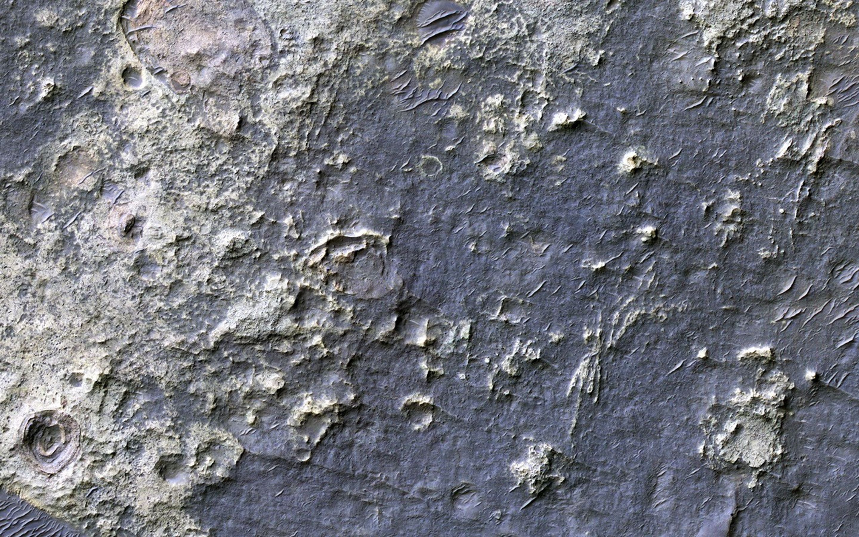 This enhanced-color image from NASA's Mars Reconnaissance Orbiter shows a patch of well-exposed bedrock on the floor of Kaiser Crater. The wind has stripped off the overlying soil, and created grooves and scallops in the bedrock.