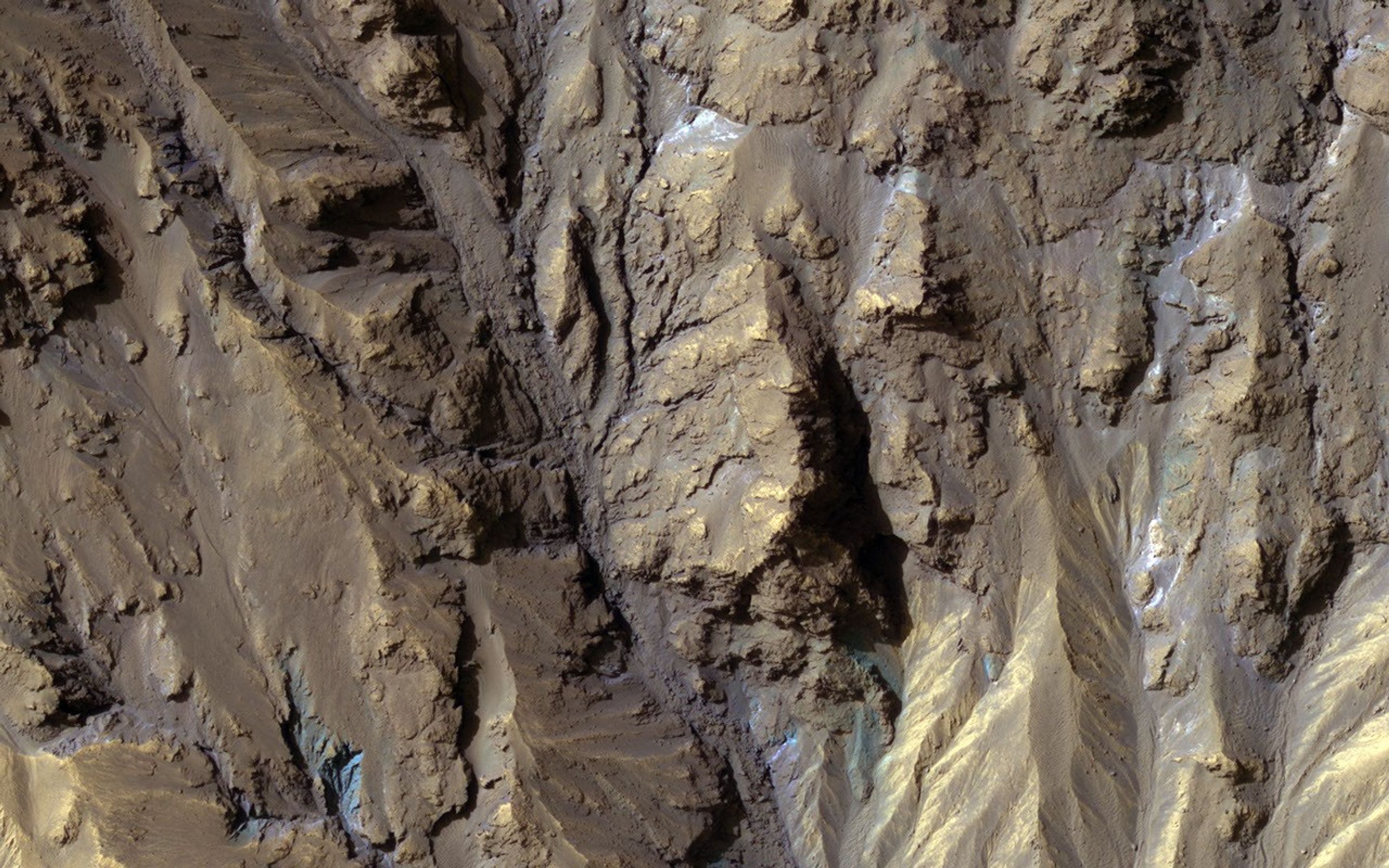 The sources of channels on the north rim of Hale Crater show fresh blue, green, purple and light toned exposures under the overlying reddish dust, captured by NASA's Mars Reconnaissance Orbiter.
