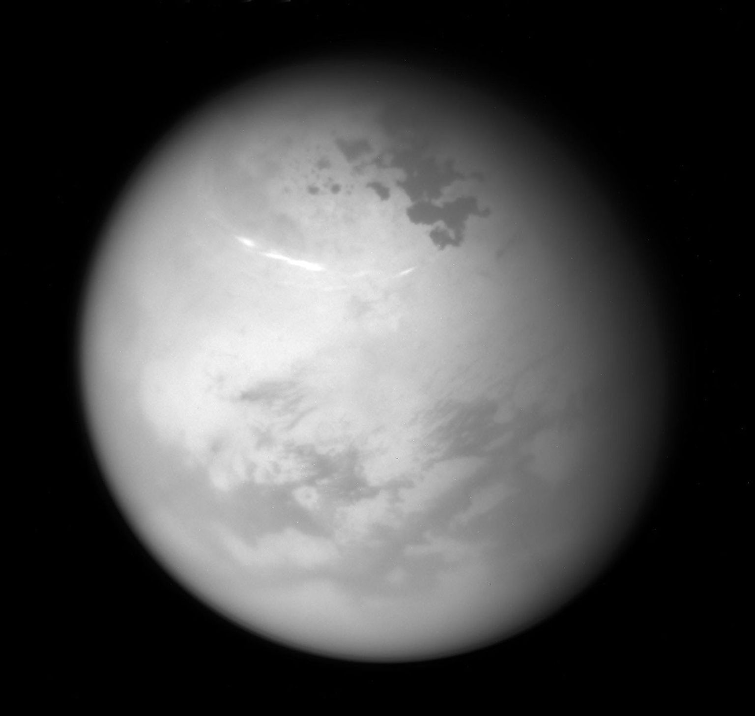 NASA's Cassini spacecraft sees bright methane clouds drifting in the summer skies of Saturn's moon Titan, along with dark hydrocarbon lakes and seas clustered around the north pole.