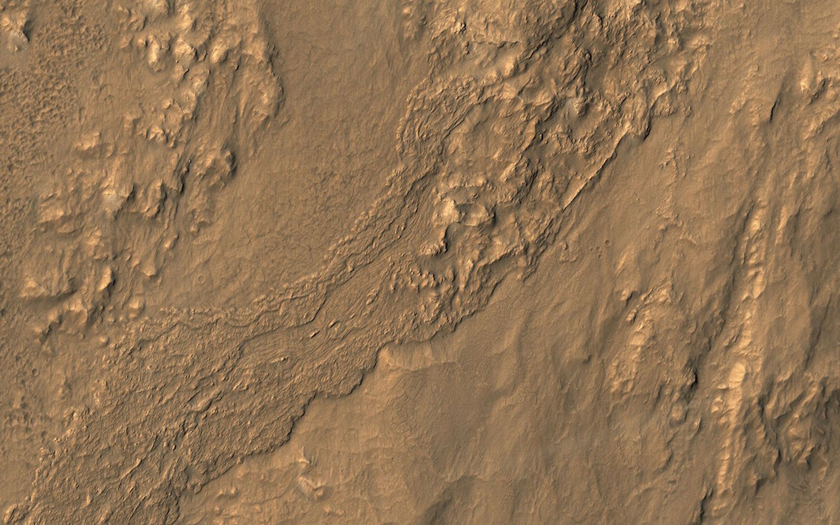 This oblique view from NASA's Mars Reconnaissance Orbiter shows a small part of the near-rim ejecta from Tooting Crater which must be either melted rock from the impact event, or a wet debris flow from melting of ice.