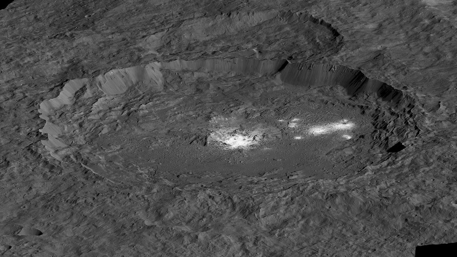 This simulated perspective view from NASA's Dawn mission shows the bright areas of Occator Crater, which contains the brightest area on Ceres, Cerealia Facula in the center and Vinalia Faculae to the side.