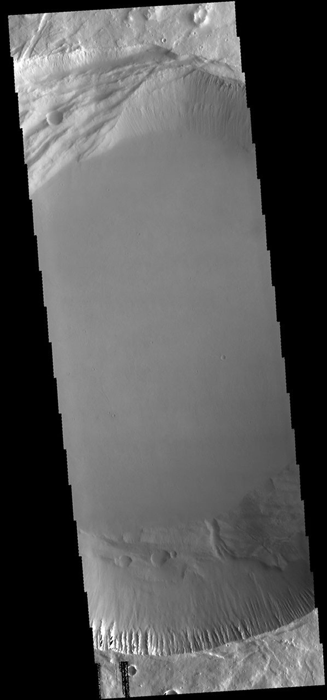 This image from NASA's 2001 Mars Odyssey spacecraft shows the central part of the smaller summit caldera on Pavonis Mons. On the top side of the caldera is a complex region of fault related collapse of the wall of the caldera.