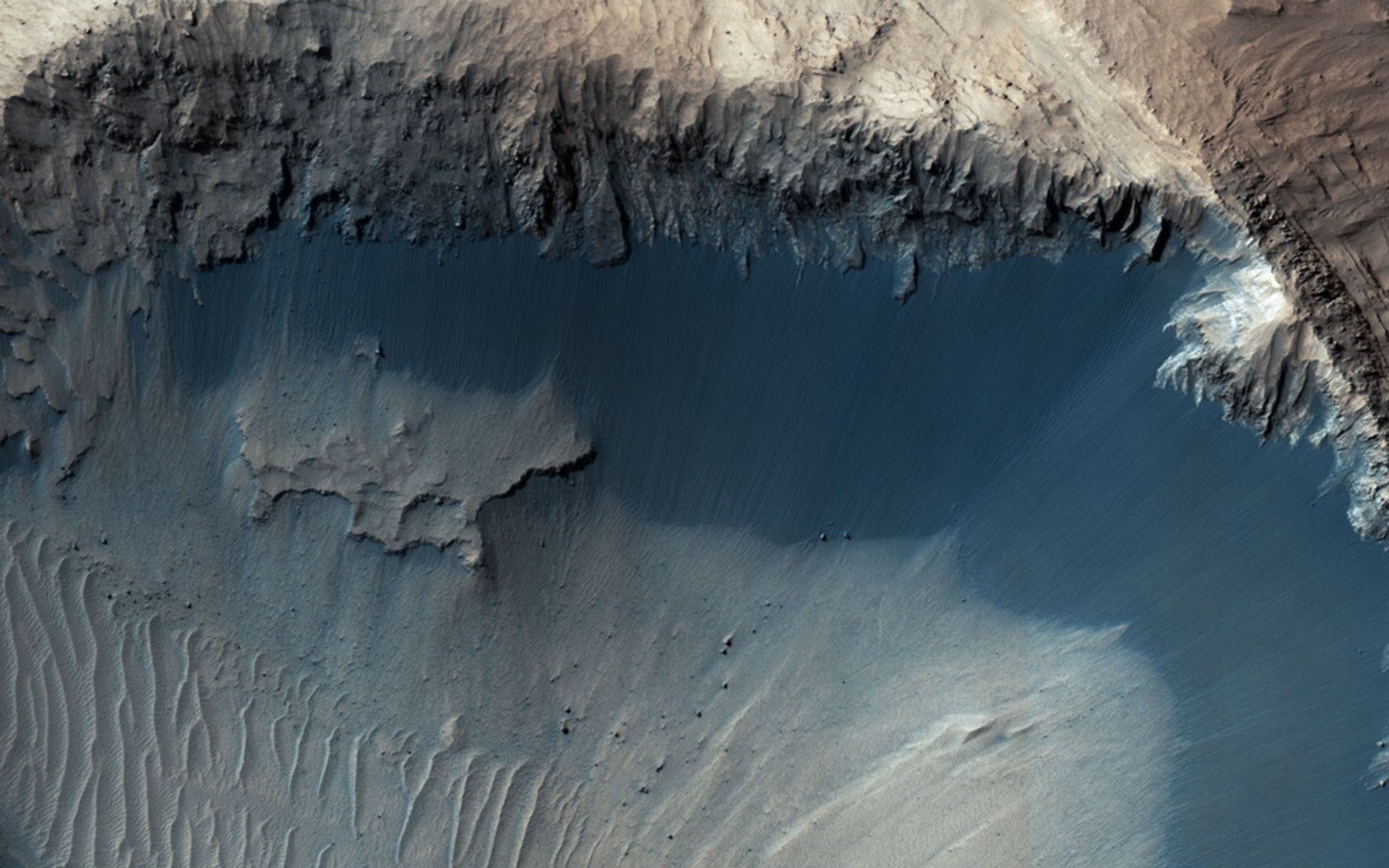 This image from NASA's Mars Reconnaisance Orbiter (MRO) shows one possible place where sand grains are being produced on Mars today. Grains of sand that make up sand dunes on Earth and Mars have a hazardous existence because of the way that they travel.