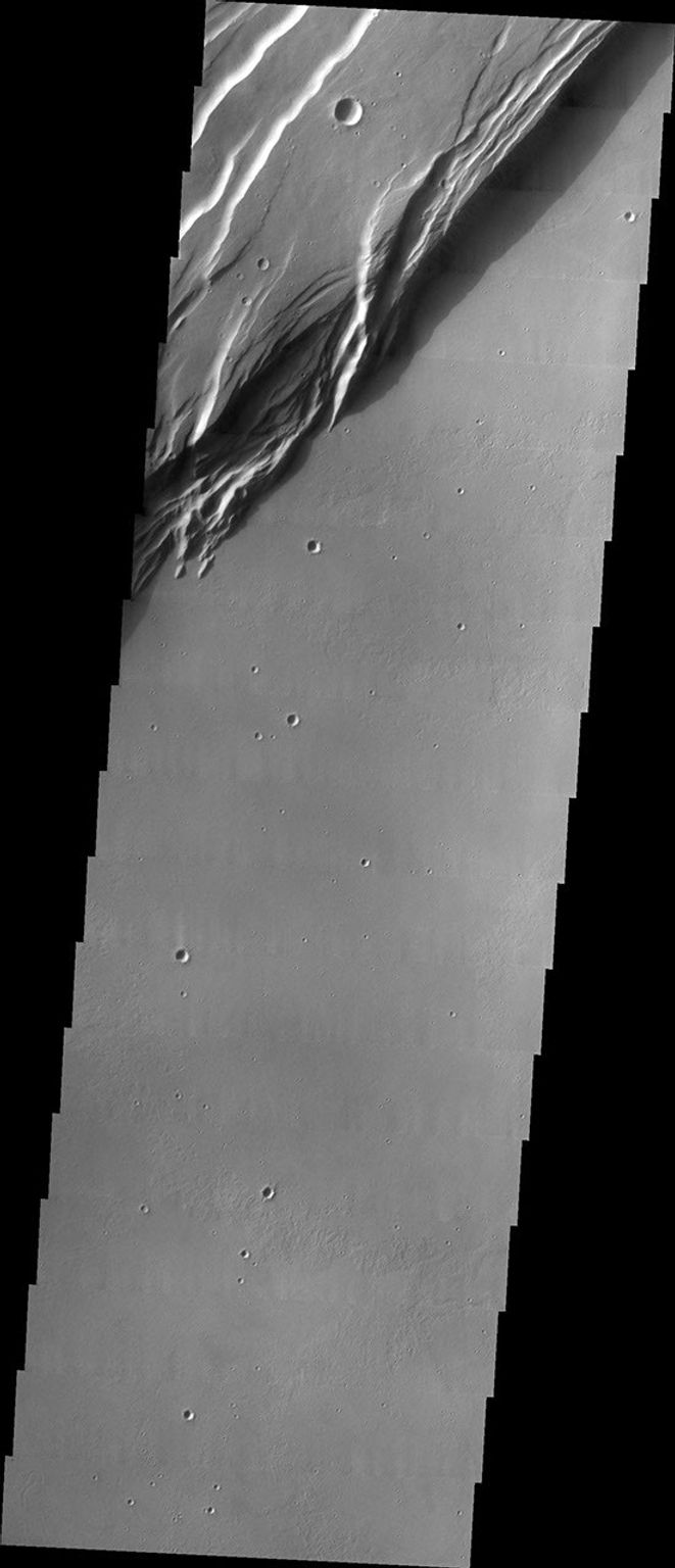 This image from NASA's 2001 Mars Odyssey spacecraft shows a portion of the western wall of the caldera, revealing the steep walls and linear features associated with the collapse that formed the caldera.
