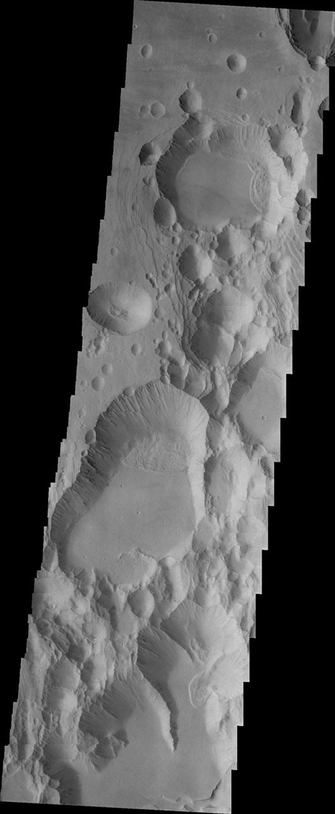The three large aligned Tharsis volcanoes are Arsia Mons, Pavonis Mons and Ascreaus Mons. This image from NASA's 2001 Mars Odyssey spacecraft shows part of the southern flank of Arsia Mons, along the center of the aligned fracture system.