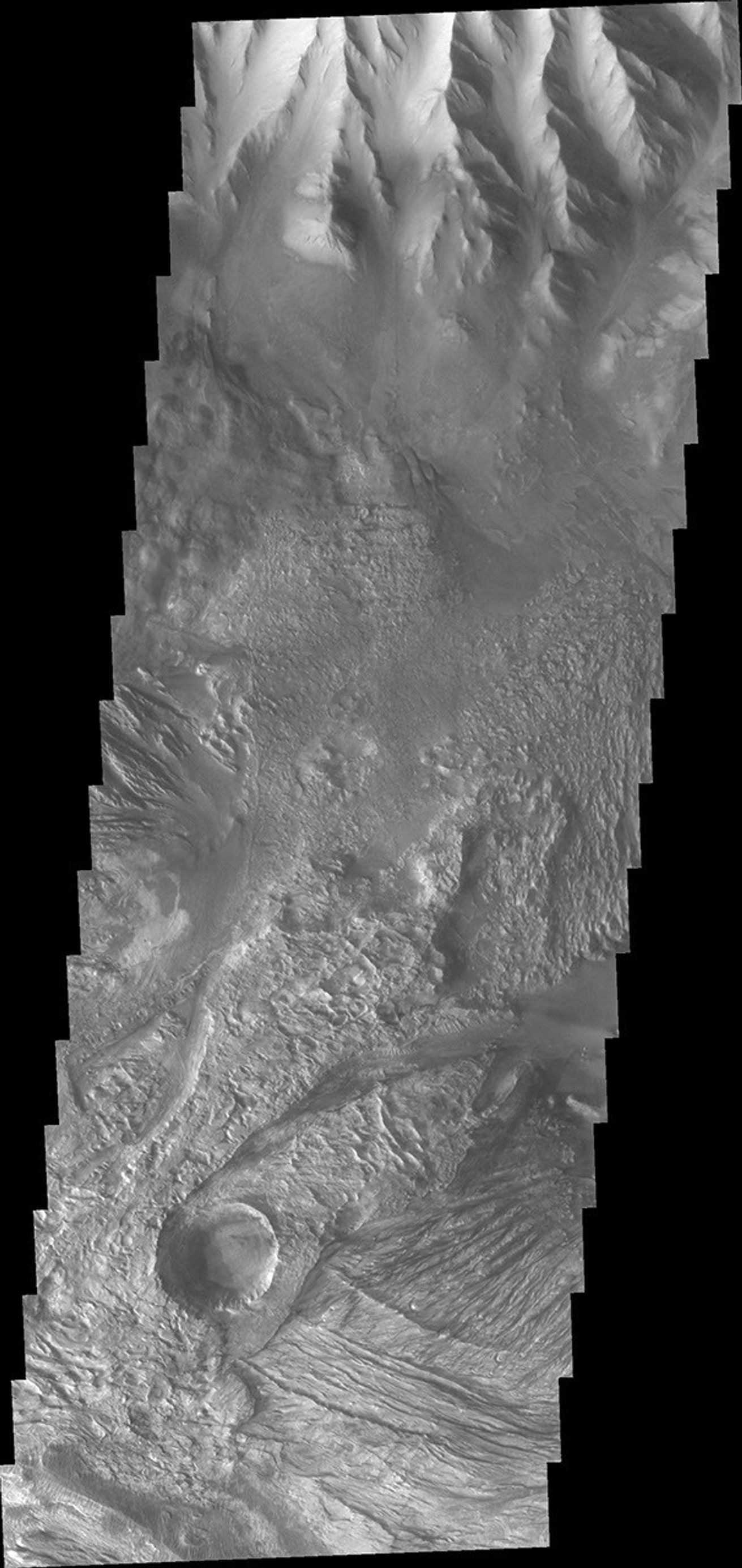This image from NASA's 2001 Mars Odyssey spacecraft shows part of western Candor Chasma. Near the bottom of the image is an impact crater. Impact craters are relatively rare within all the canyons of Valles Marineris.