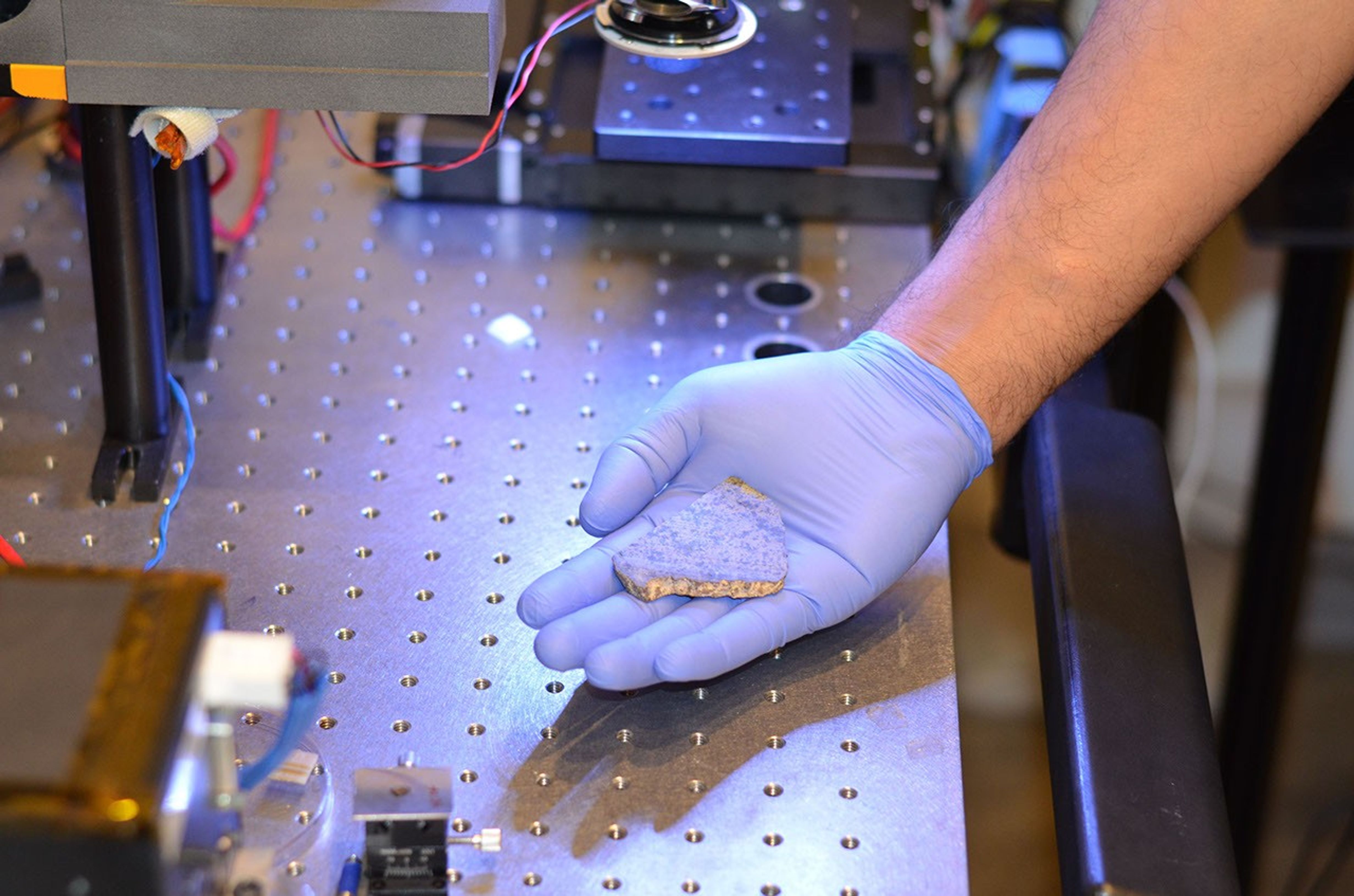 Rohit Bhartia of NASA's Mars 2020 mission holds a slice of a meteorite scientists have determined came from Mars. This slice will likely be used here on Earth for testing a laser instrument for NASA's Mars 2020 rover.
