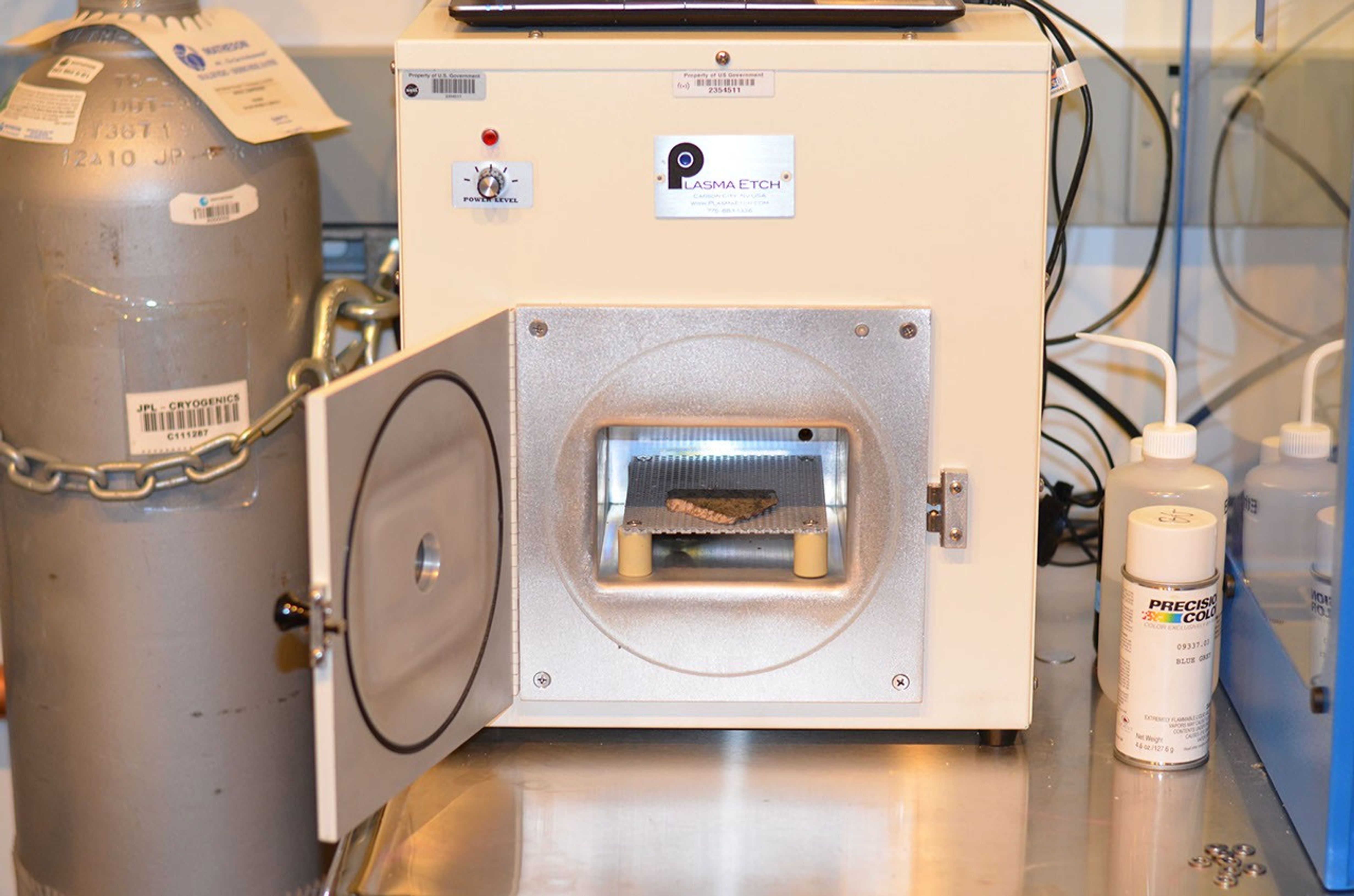 A slice of a meteorite scientists have determined came from Mars placed inside an oxygen plasma cleaner. This slice will likely be used here on Earth for testing a laser instrument for NASA's Mars 2020 rover.