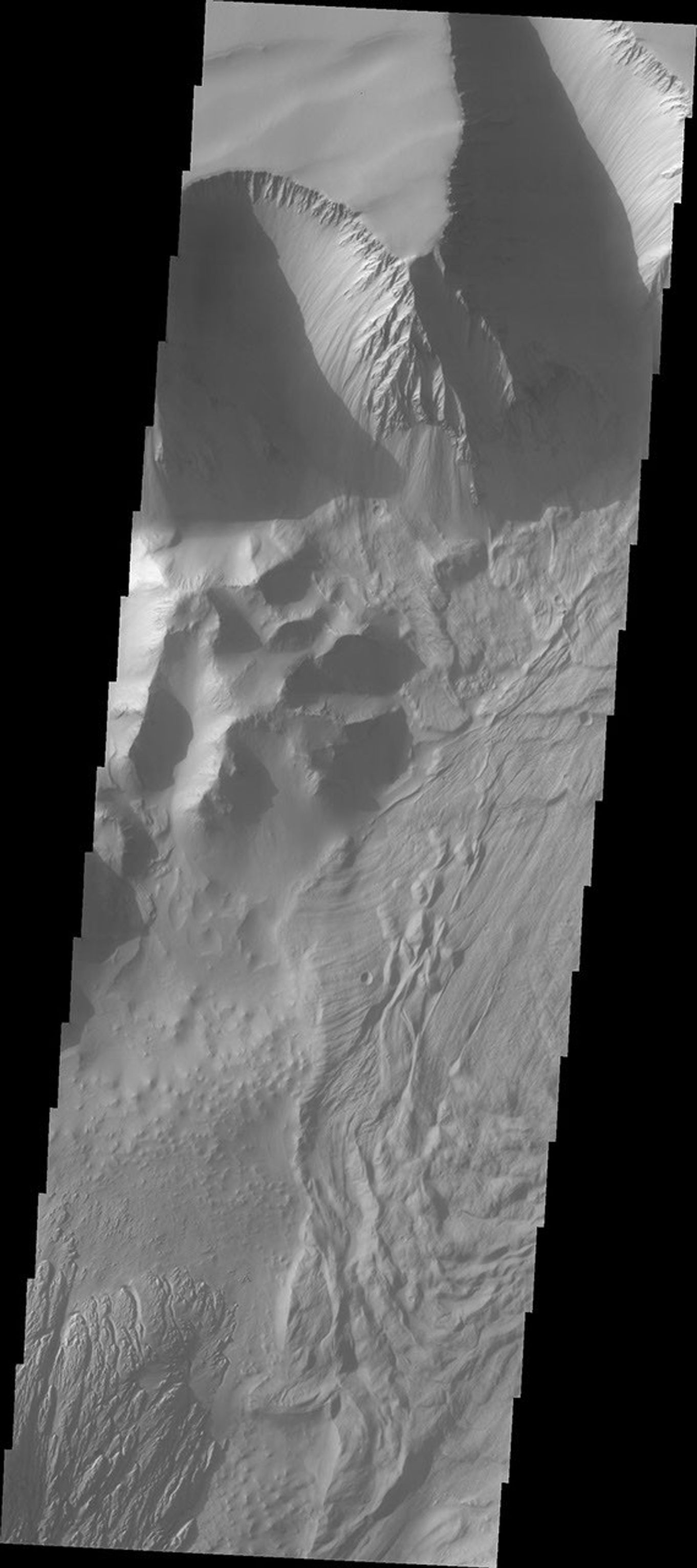 This image captured by NASA's 2001 Mars Odyssey spacecraft shows part of the central region of Tithonium Chasma. The steep wall of the canyon is visible at the top of the image.
