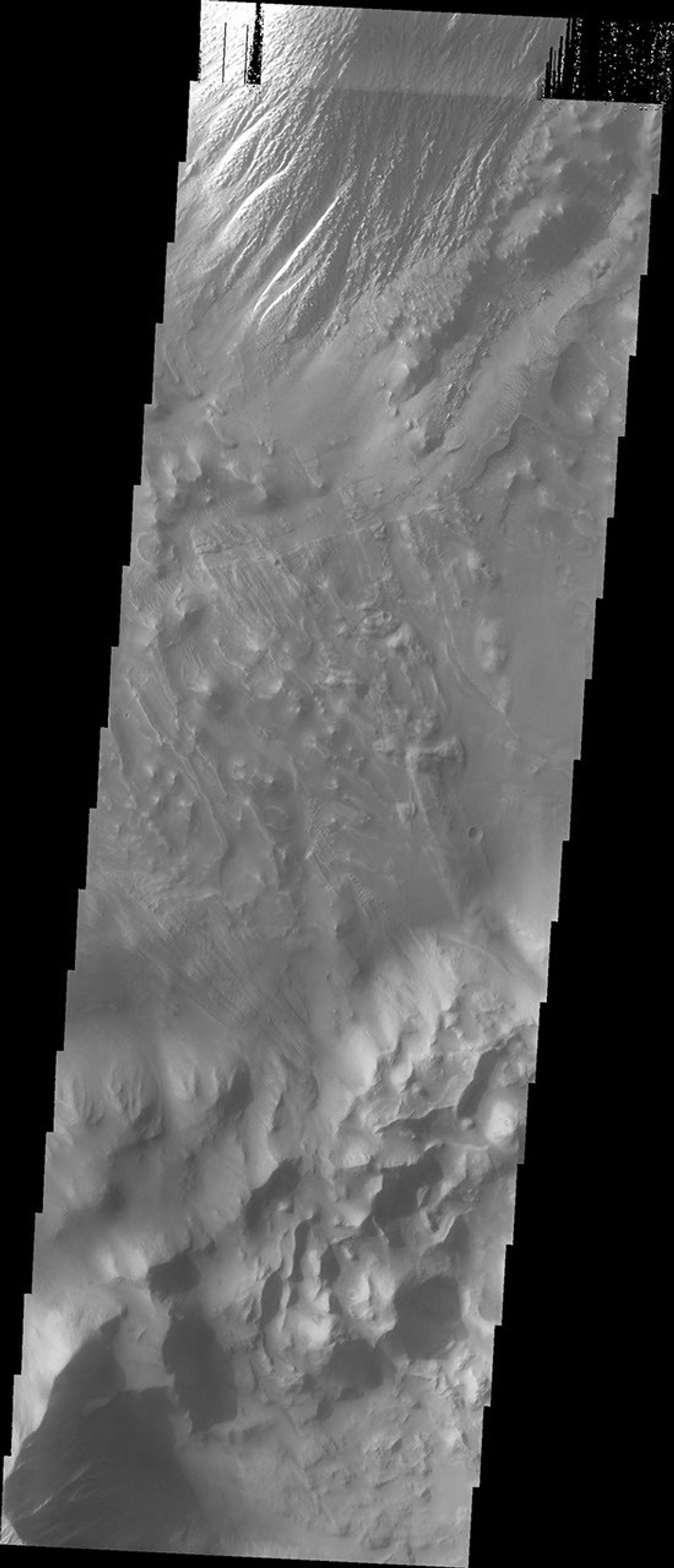 This image captured by NASA's 2001 Mars Odyssey spacecraft shows part of the floor of Tithonium Chasma. Eroded materials cover most of the image.