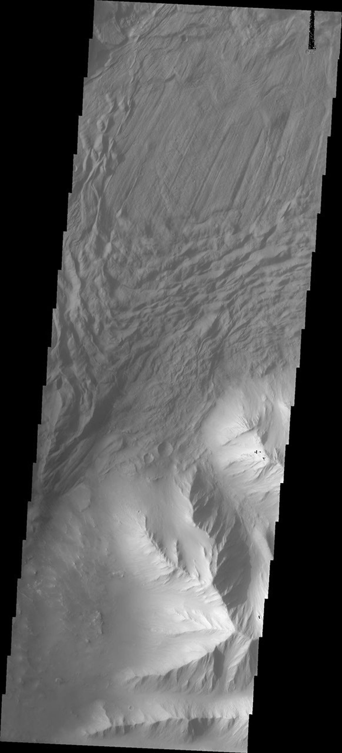 In this image captured by NASA's 2001 Mars Odyssey spacecraft a complex region of multiple overlapping landslide deposits fills most the the frame. The very top layer has the lobate edges and radial surface grooves of a low volume slide.