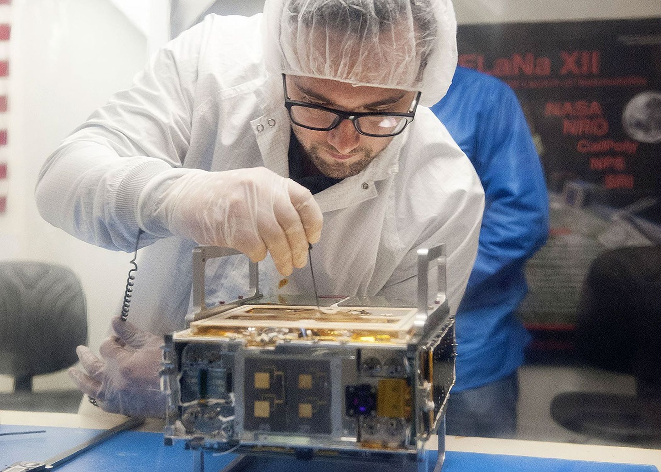 Joel Steinkraus, MarCO lead mechanical engineer from JPL, makes an adjustment on the CubeSat prior to integration in a deployment box as seen inside the cleanroom lab at Cal Poly San Luis Obispo on Monday, March 12, 2018.