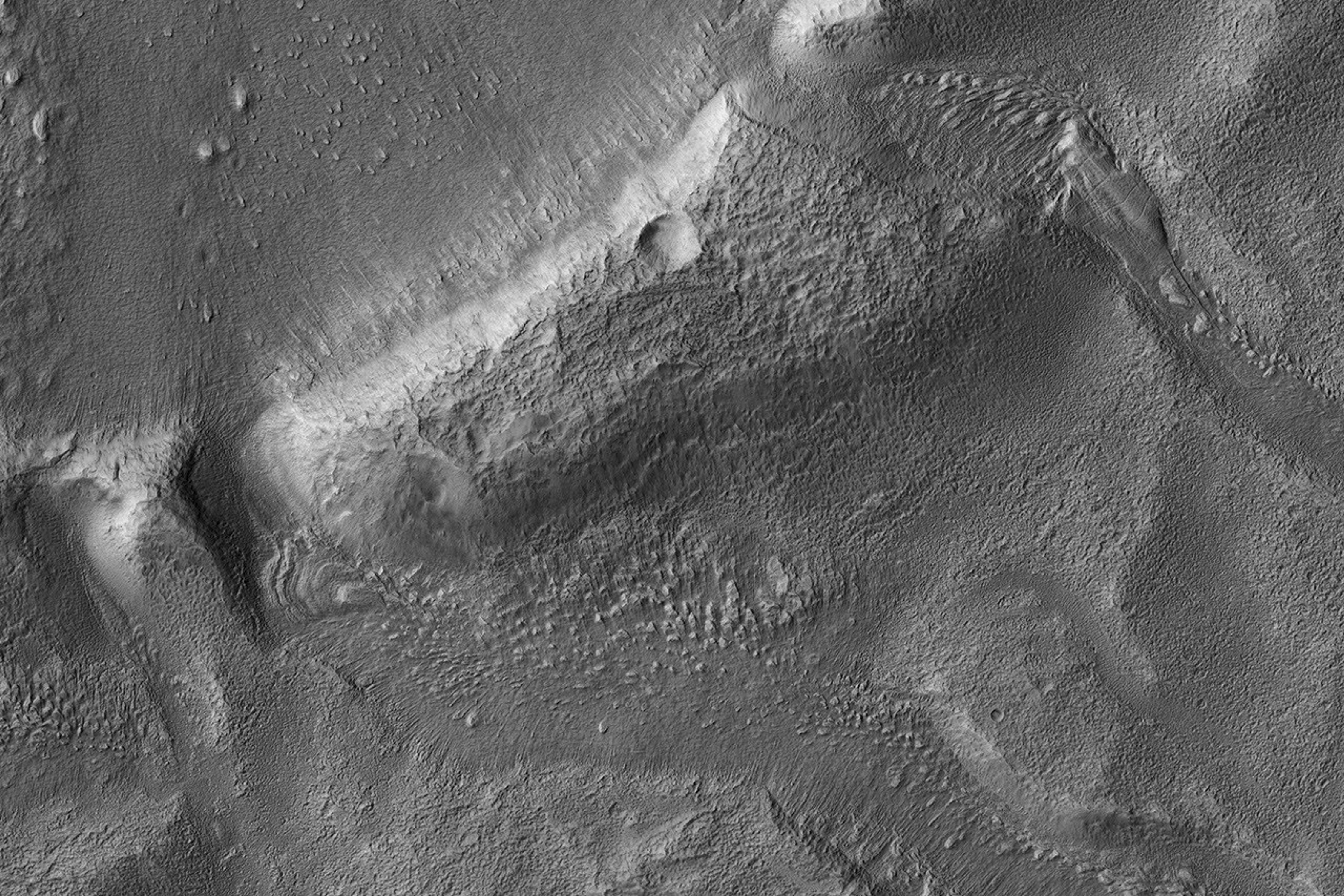 This image from NASA's Mars Reconnaissance Orbiter shows a roundish crater with three channels breaching the rim and extending to the south. The crater has been filled by sediments and may have been an ancient lake.