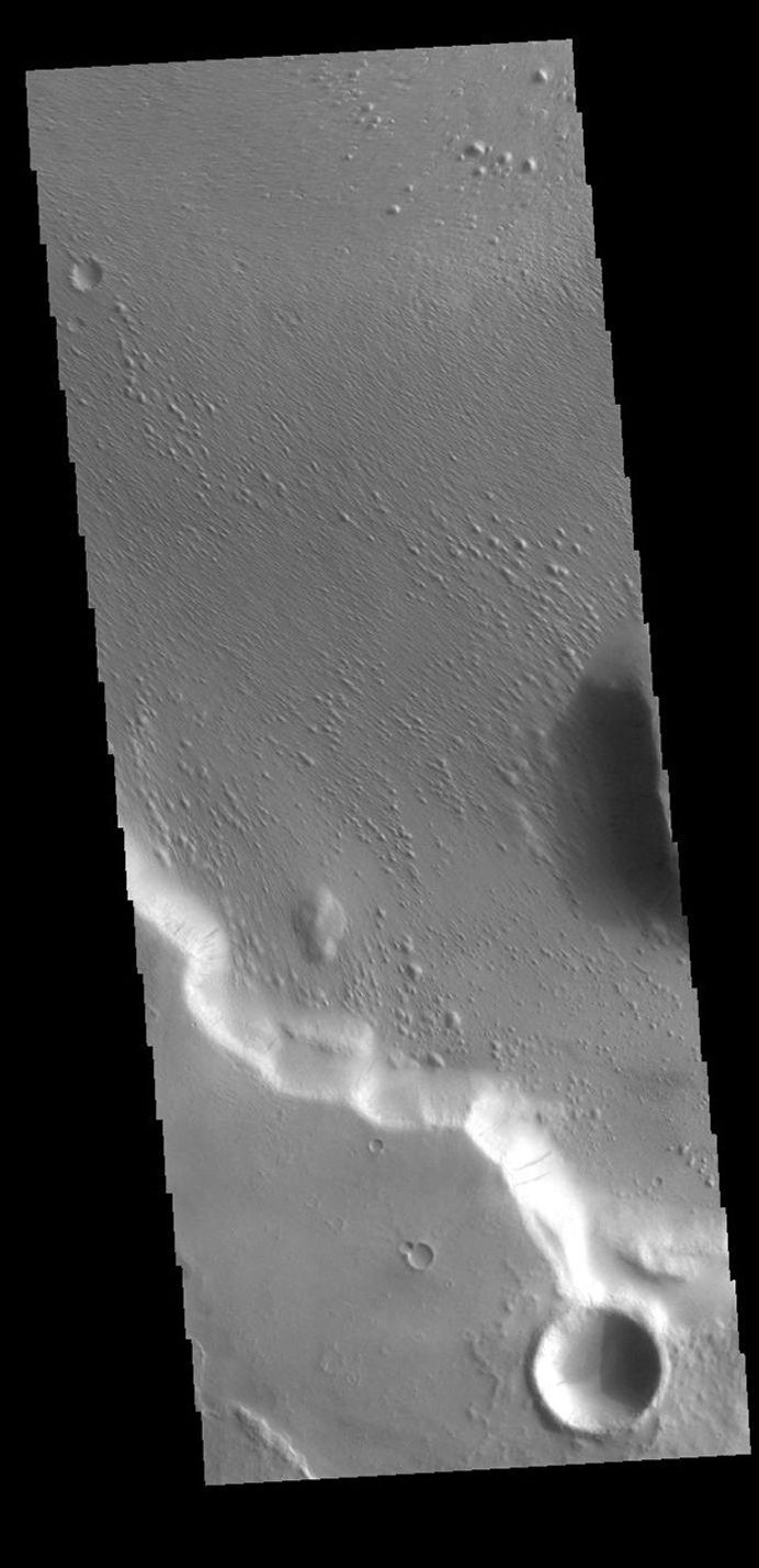 This image captured by NASA's 2001 Mars Odyssey spacecraft is located in Medusae Fossae. Along the cliffside several dark streaks are visible.