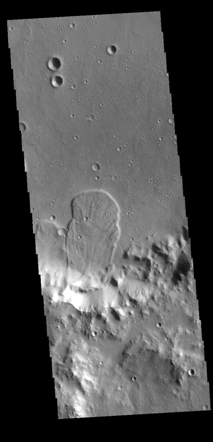 This image captured by NASA's 2001 Mars Odyssey spacecraft is located in an unnamed crater within Tyrrhena Terra. The 'mitten' shaped feature extends from the crater rim (bottom of frame) onto the crater floor.