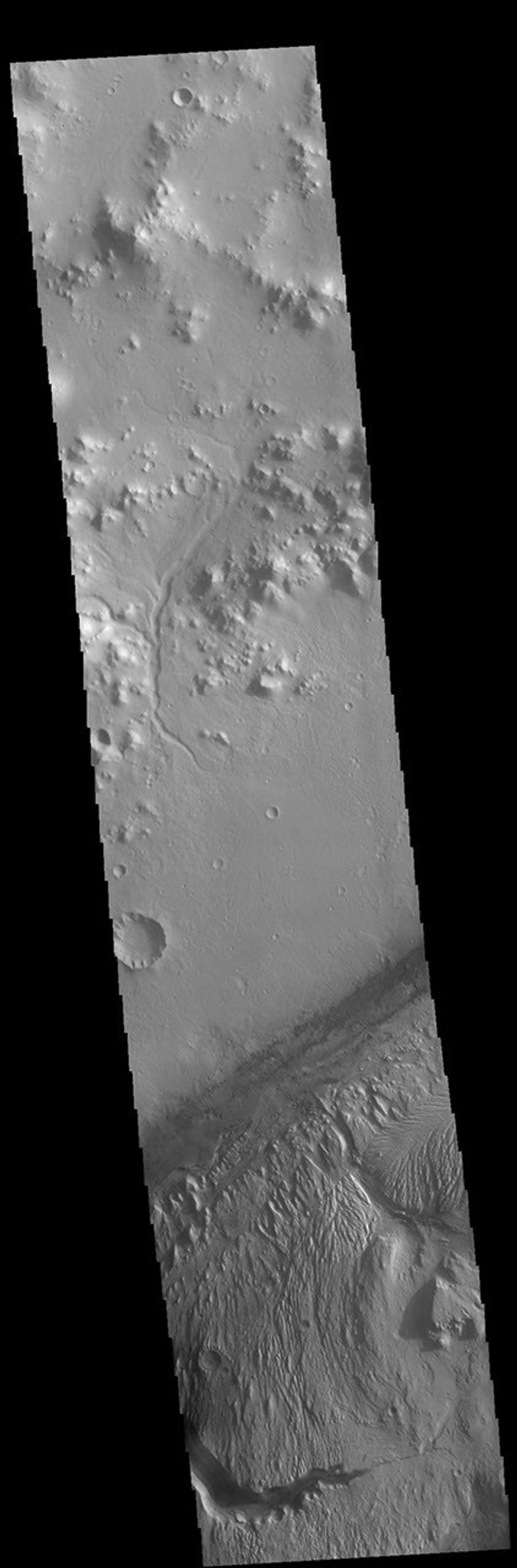 This image of Gale Crater from NASA's 2001 Mars Odyssey spacecraft shows part of the huge layered deposit that covers much of the crater floor. The top of the image shows part of the crater rim, including one of the many small channels.