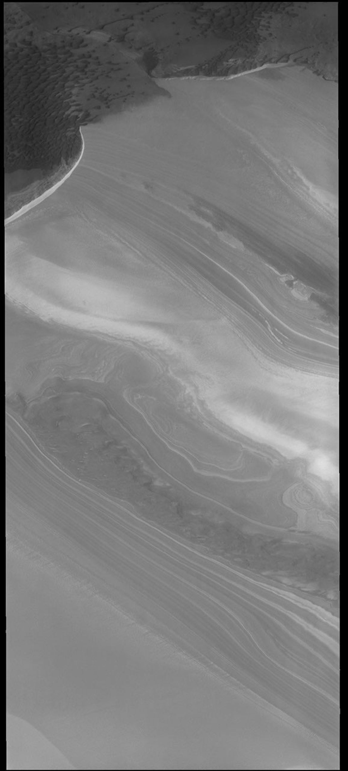 This image captured by NASA's 2001 Mars Odyssey spacecraft shows the margin between the polar cap and the surrounding plains. There are dunes on the plains at the top of the image.