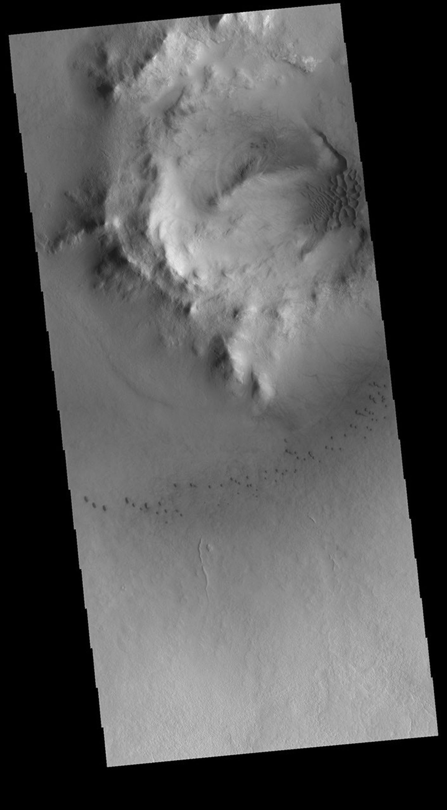 Milankovic Crater is located in central Arcadia Planitia. This image from NASA's 2001 Mars Odyssey spacecraft shows small sand dunes on the crater floor, and larger dunes within the central crater peak/pit feature.