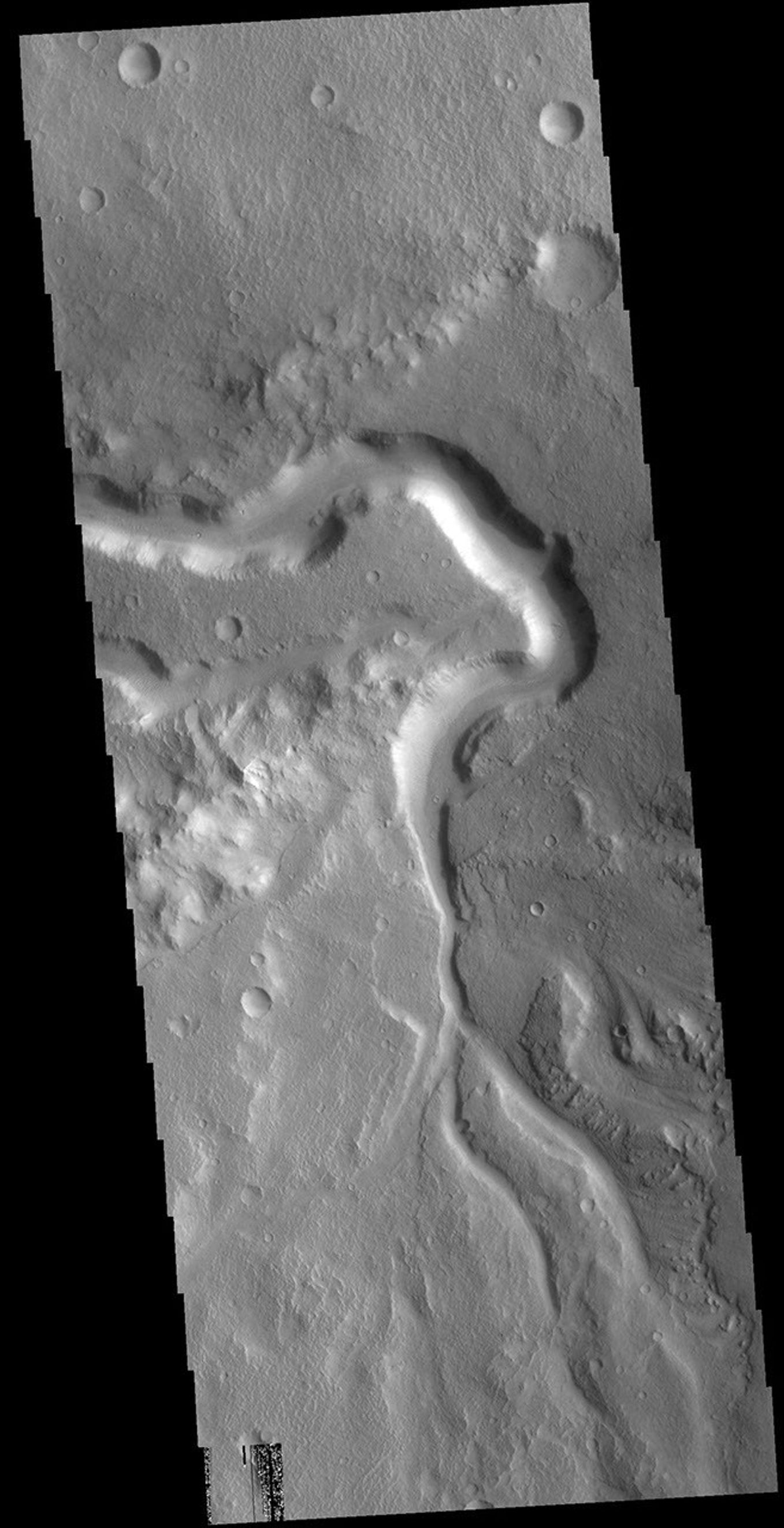 This image from NASA's Mars Odyssey shows an unnamed channel in Xanthe Terra. The large bend in the channel was created as the flow of liquid from the bottom of the image was deflected by a ridge that extends diagonally from the left center.