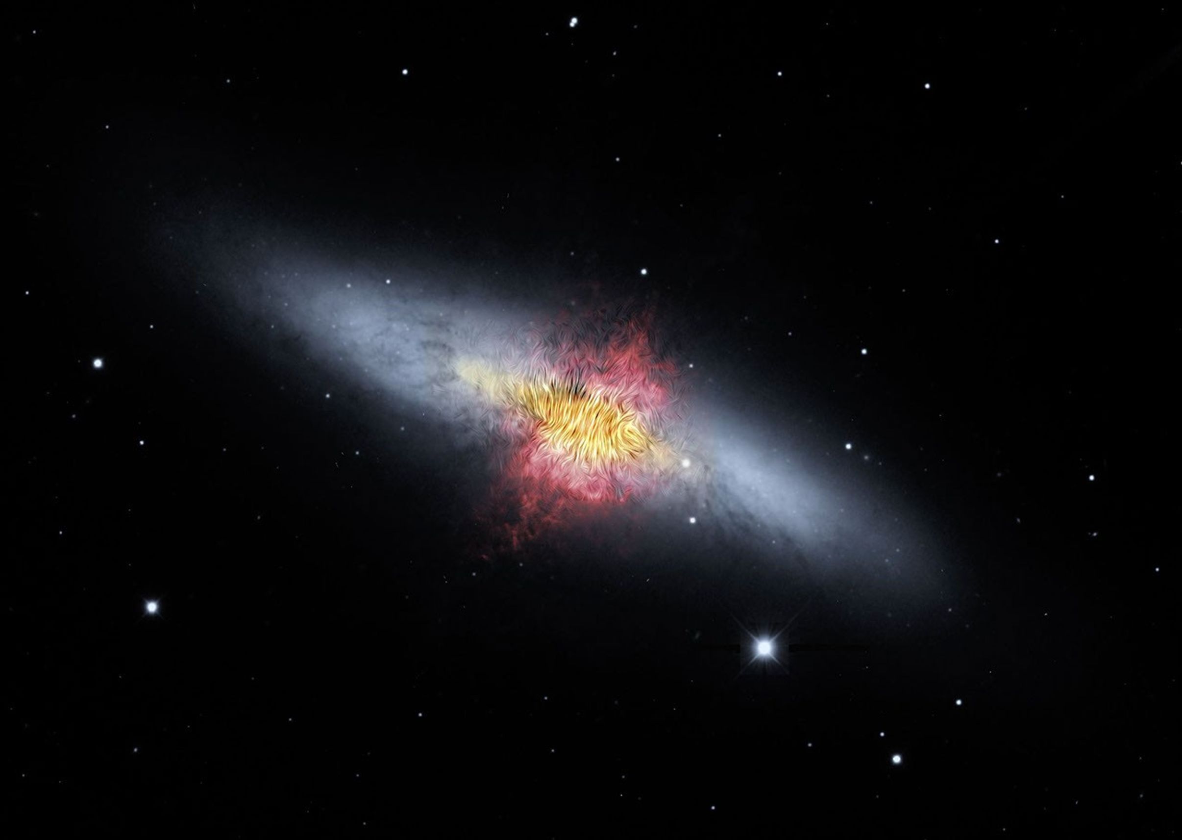 The magnetic field lines of the the Cigar Galaxy (also called M82) appear in this composite image produced by NASA's Spitzer Space Telescope. The lines follow the bipolar outflows (red) generated by exceptionally high rates of star formation.