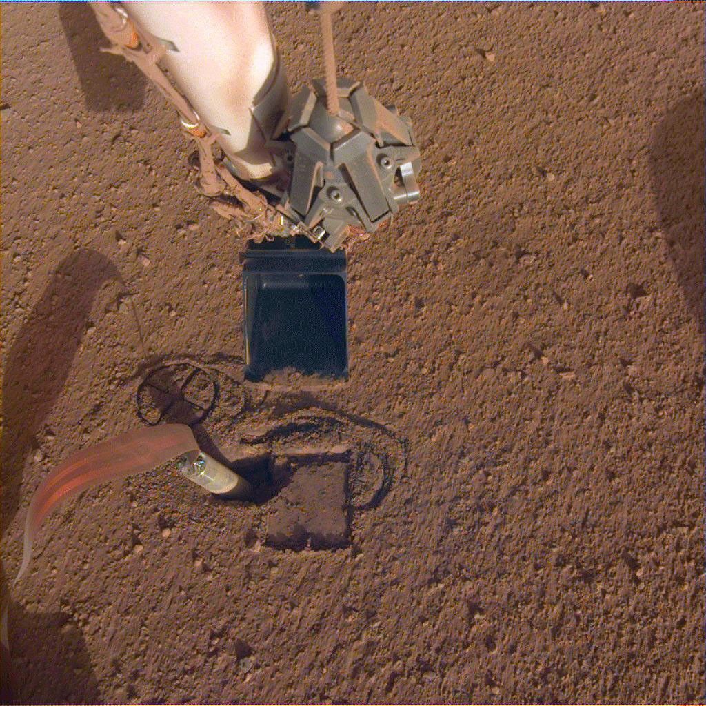 NASA InSight's robotic arm will use its scoop to pin the spacecraft's heat probe, or 'mole,' against the wall of its hole.