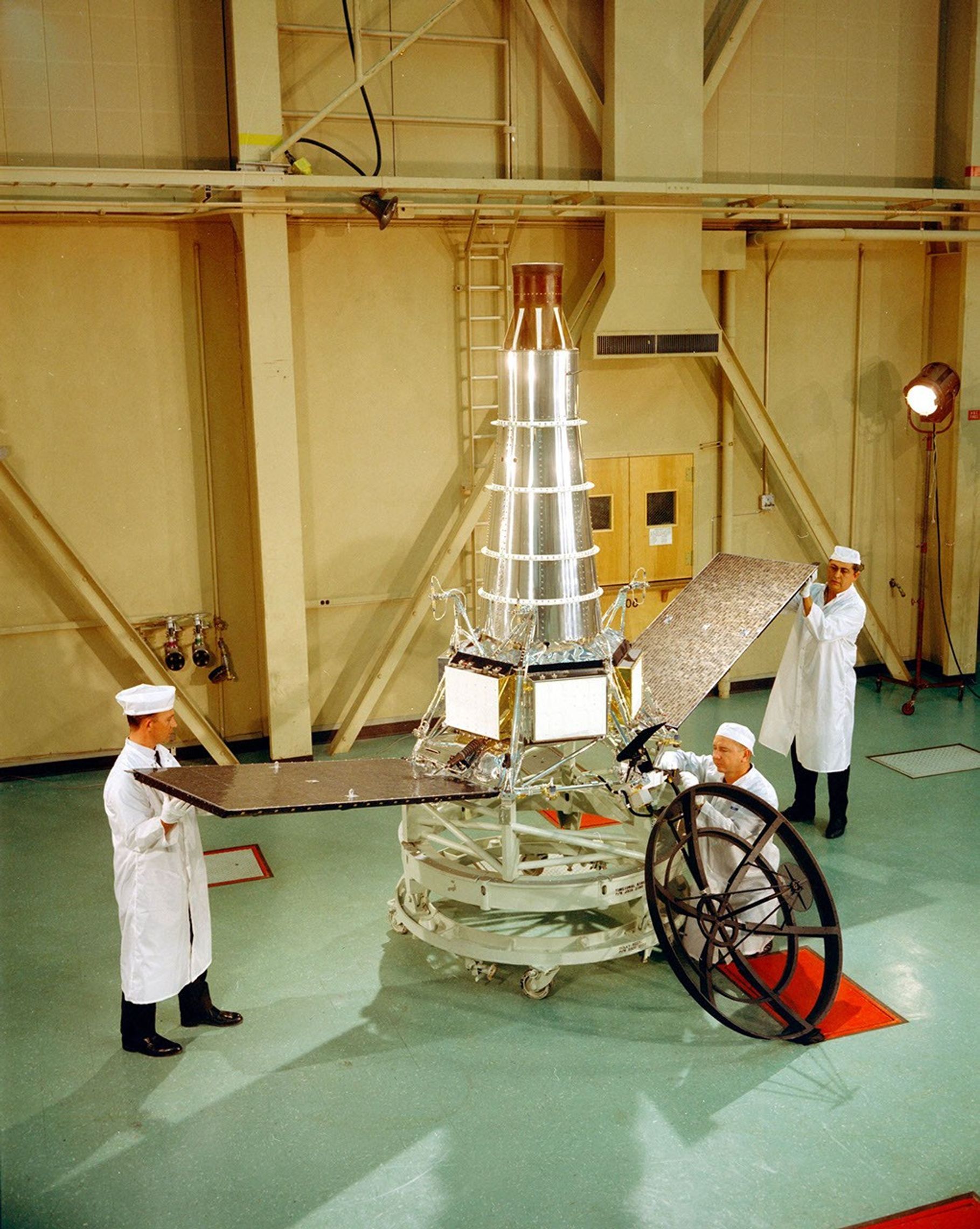 Engineers stand with Ranger 7 on Dec. 10, 1963, in High Bay 1, located at NASA's Jet Propulsion Laboratory.