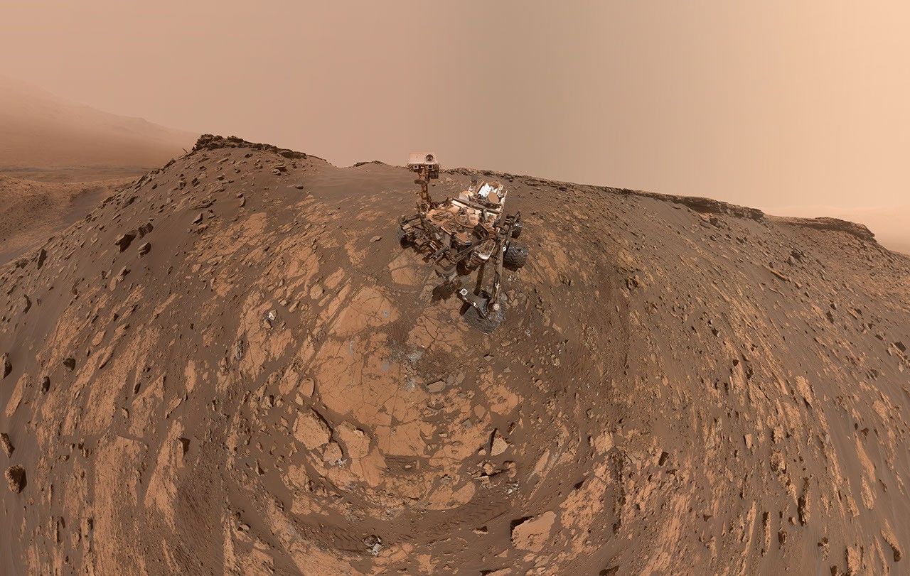 This selfie was taken by NASA's Curiosity Mars rover on Feb. 26, 2020. The crumbling rock layer at the top of the image is the Greenheugh Pediment, which Curiosity climbed soon after taking the image.