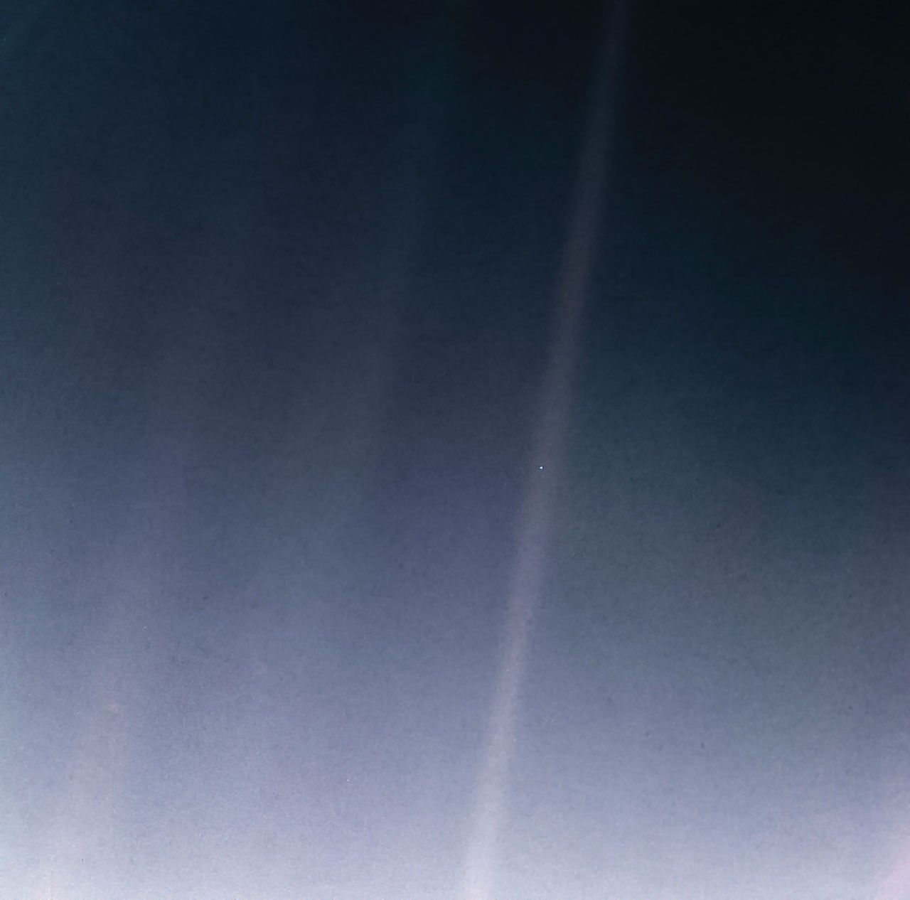 Earth as a tiny bluish dot suspended in a grainy beam of light., a speck in the vast emptiness that fills the rest of the frame.