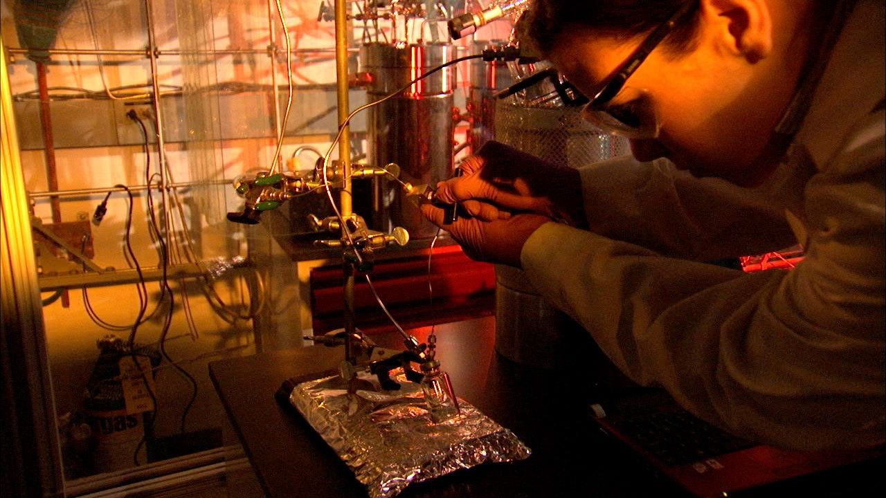 A scientist at NASA's Jet Propulsion Laboratory, adjusts an experiment that simulates how ancient seawater and fluid from hydrothermal vents could have reacted with minerals from the seafloor to create organic molecules.