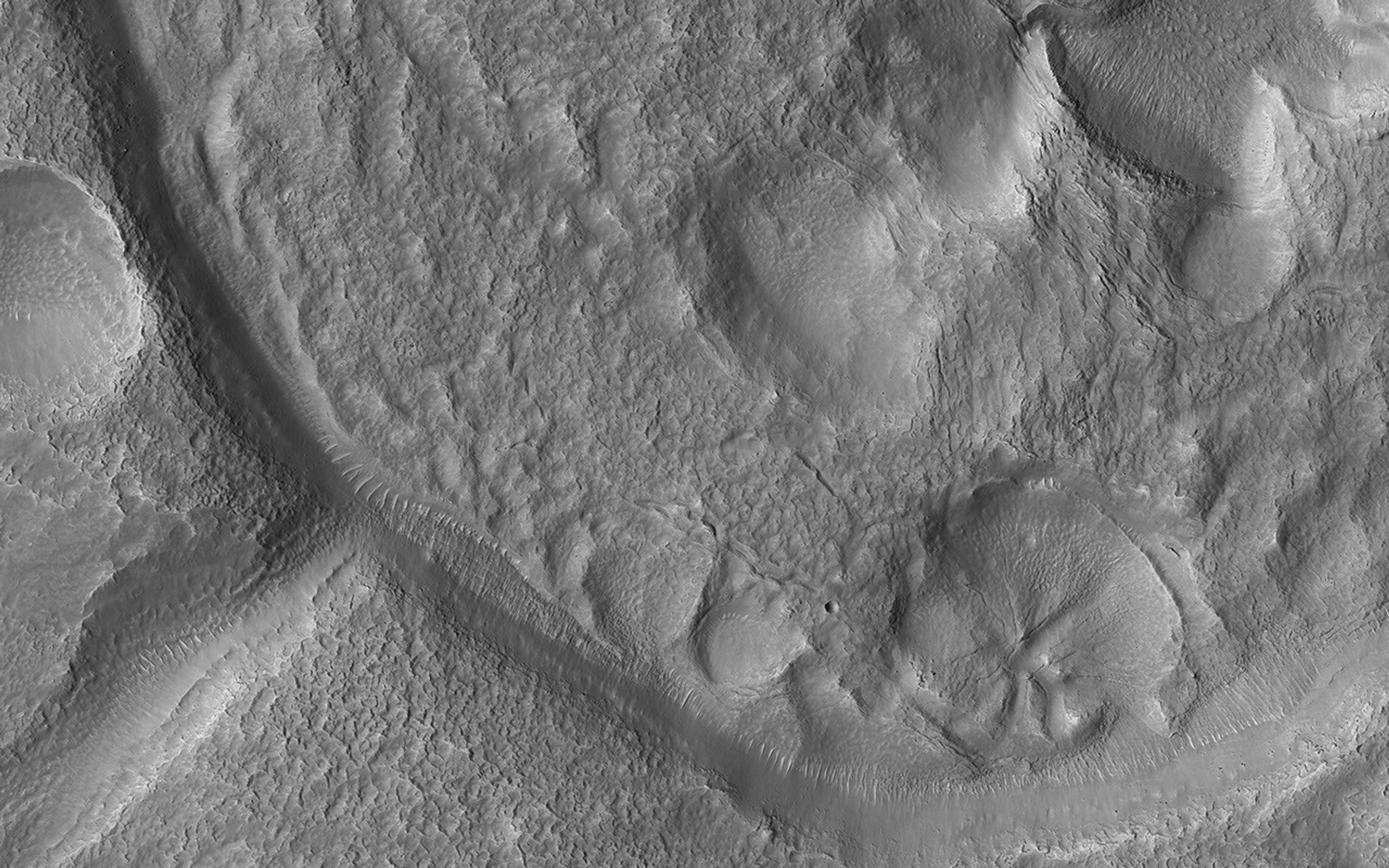 This image acquired on September 30, 2019 by NASA's Mars Reconnaissance Orbiter, shows a small crater, probably once filled with an ice-covered lake that overflowed, forming the exit channel.