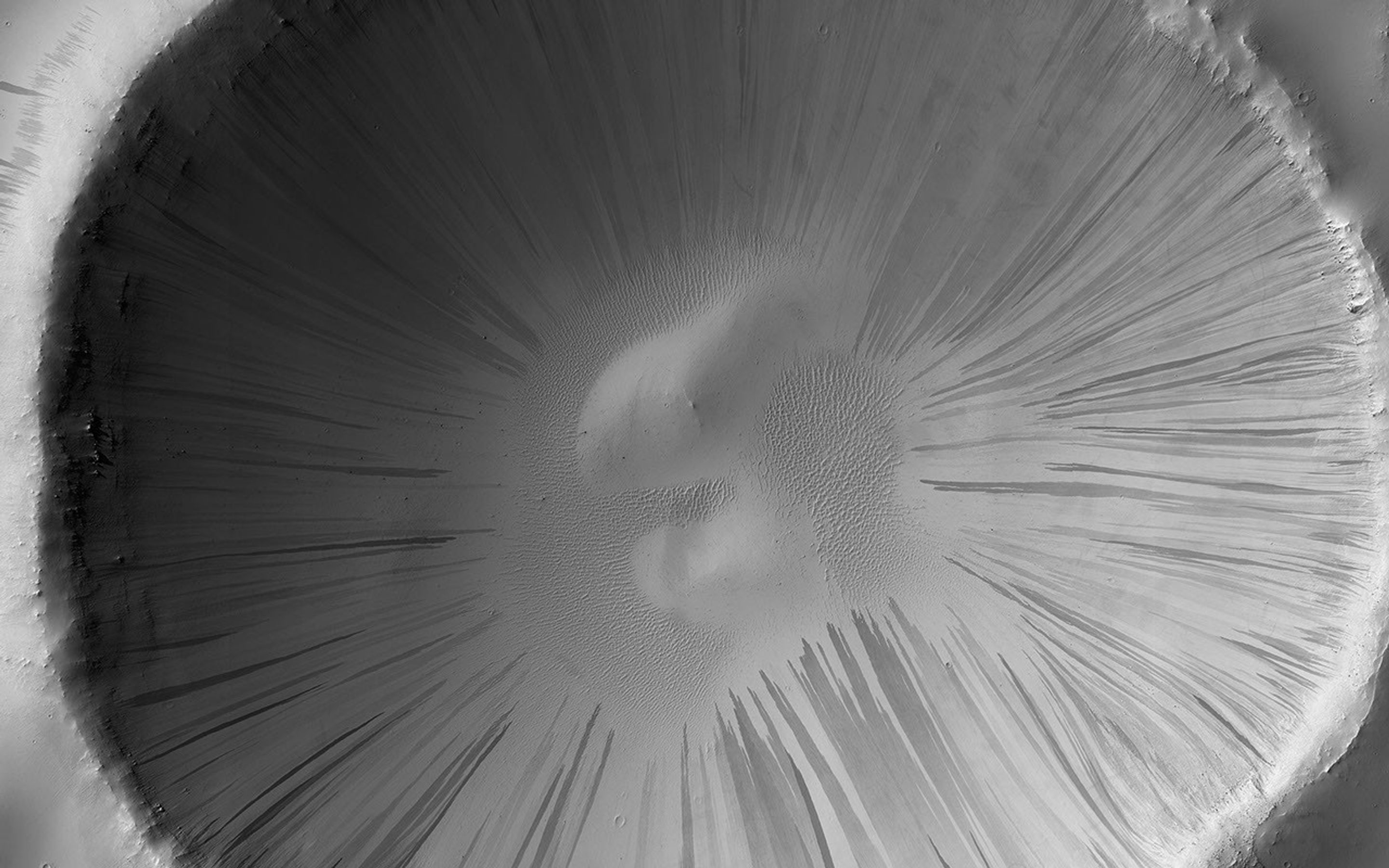 This image acquired on January 20, 2020 by NASA's Mars Reconnaissance Orbiter, shows dark slope streaks on the slopes of this crater, thought to be the result of the relatively bright colored dust avalanching down.