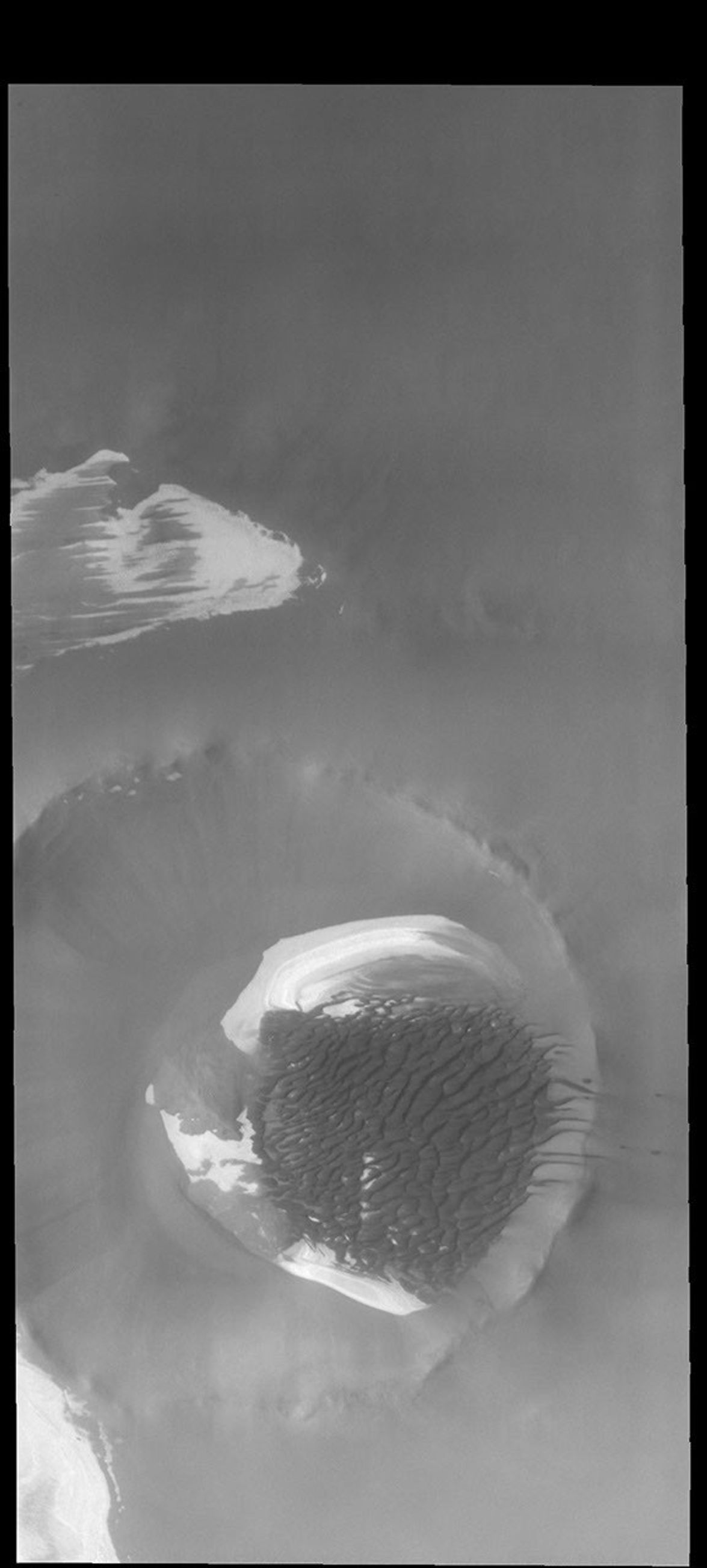This image from NASA's Mars Odyssey shows Inuvik Crater. Located near the north polar cap, this crater is 20 km (12 miles) in diameter.