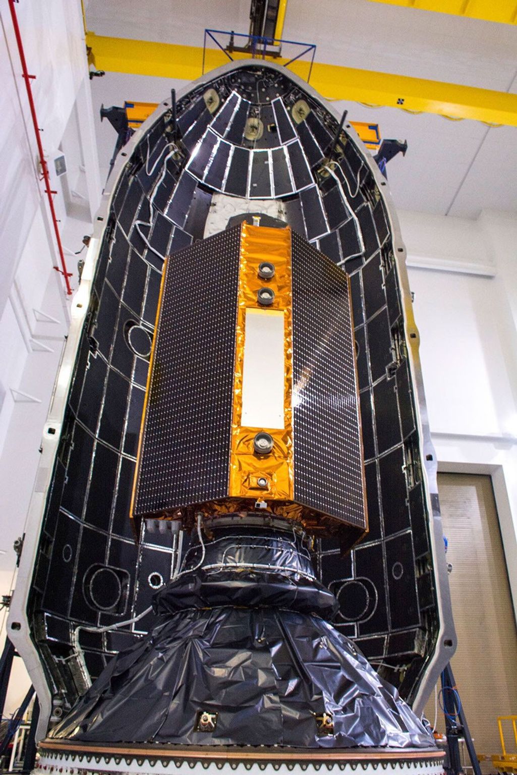 The Sentinel-6 Michael Freilich satellite is encapsulated in a protective nosecone, or payload fairing, at Vandenberg Air Force Base in California. The fairing will sit atop a SpaceX Falcon 9 rocket that will launch the satellite into Earth orbit.