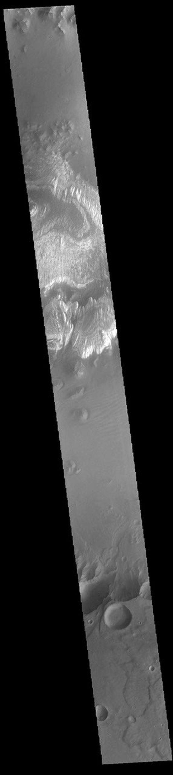This image from NASA's Mars Odyssey shows part of the floor of Ganges Chasma. Deposits of fine surface materials and bright layered deposits are visible in this image.