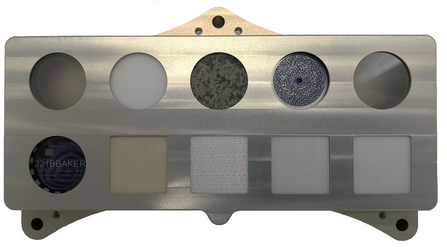 The calibration target for SHERLOC, one of the instruments aboard NASA's Perseverance Mars rover, features a slice of Martian meteorite, plus spacesuit materials, including helmet-visor material that doubles as a geocache target.
