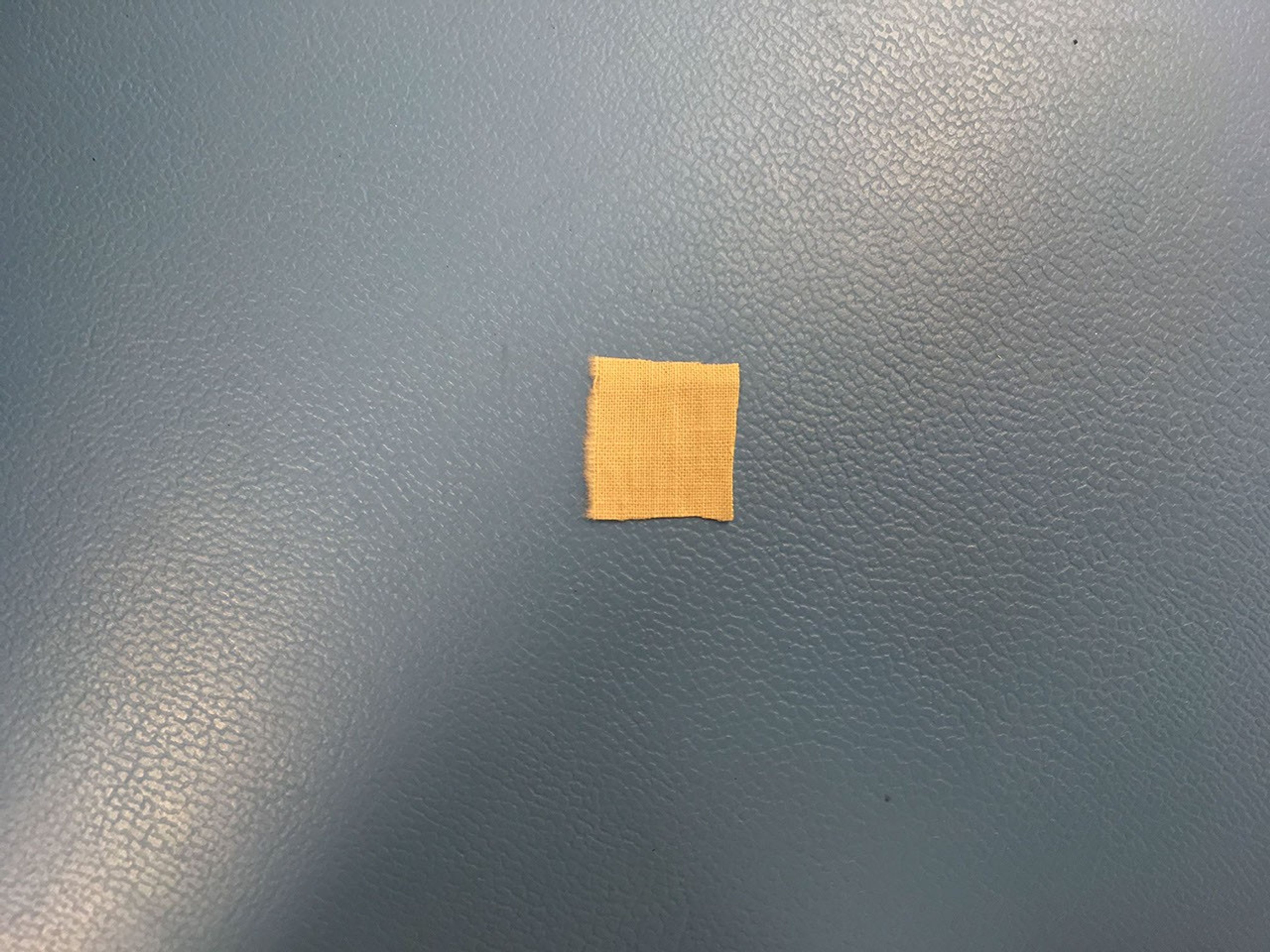 This square of unbleached muslin material from the Wright brothers' first airplane was encapsulated in a protective polyamide film before being attached to a cable underneath the solar panel of NASA's Ingenuity Mars Helicopter.