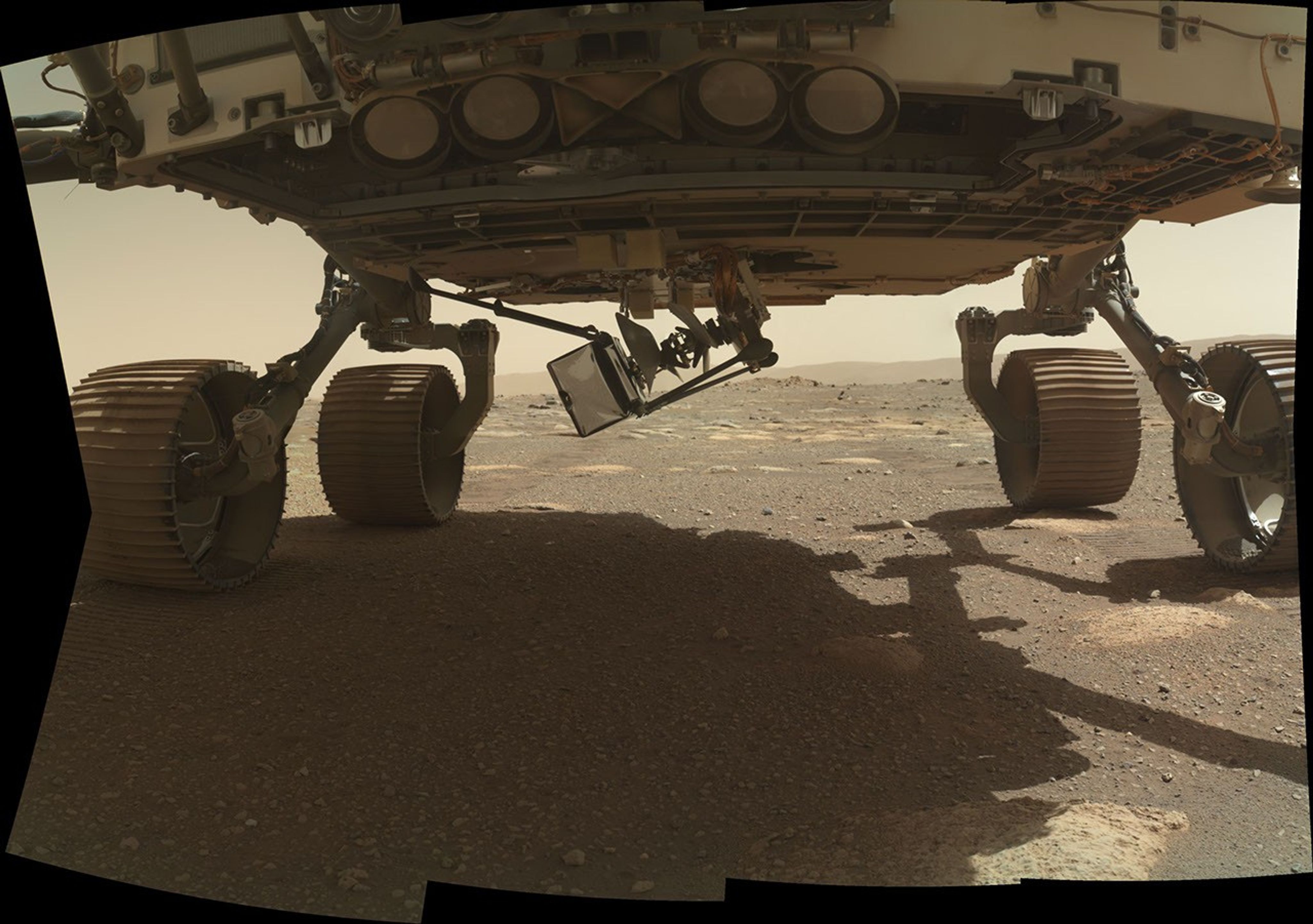 NASA's Ingenuity Mars Helicopter swings down, with two of its four legs extended, from the belly of the Perseverance rover on March 28, 2021, the 37th Martian day, or sol, of the mission.