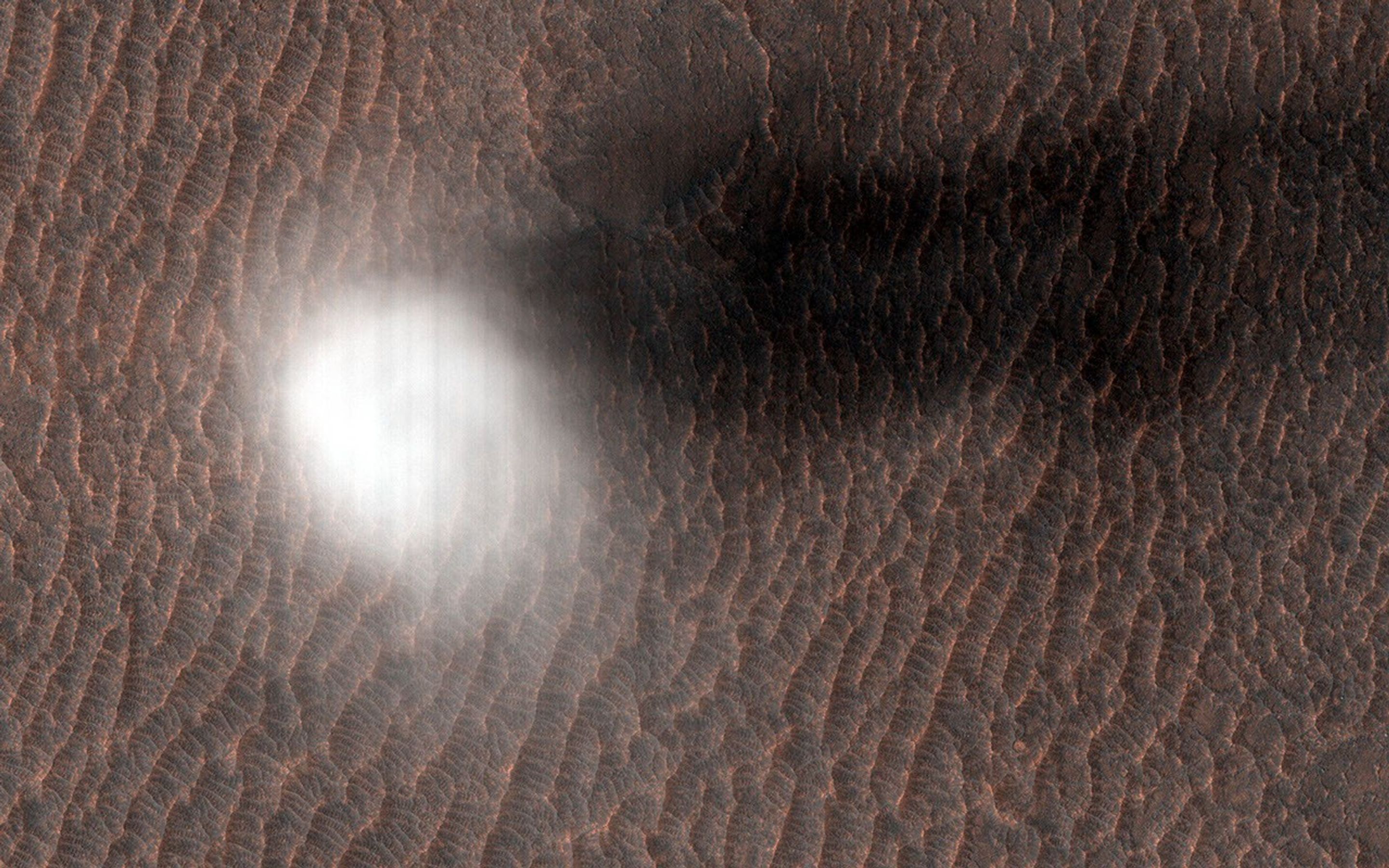 This image acquired on October 30, 2020 by NASA's Mars Reconnaissance Orbiter, shows a dust devil forming by rising and rotating warm air pockets.